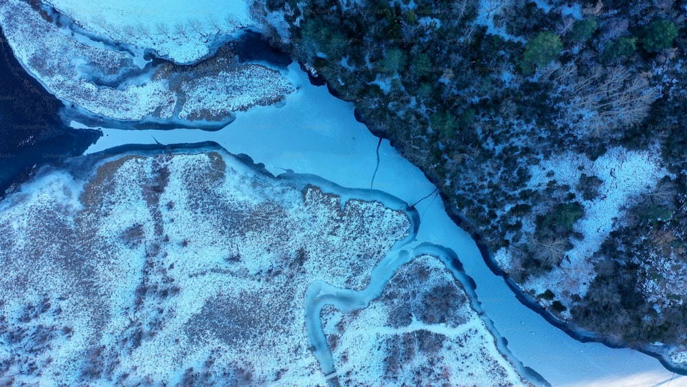 an aerial view of a river in the snow