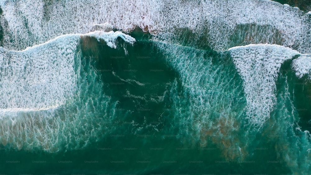 une vue aérienne de l’océan avec des vagues qui s’écrasent sur les rochers