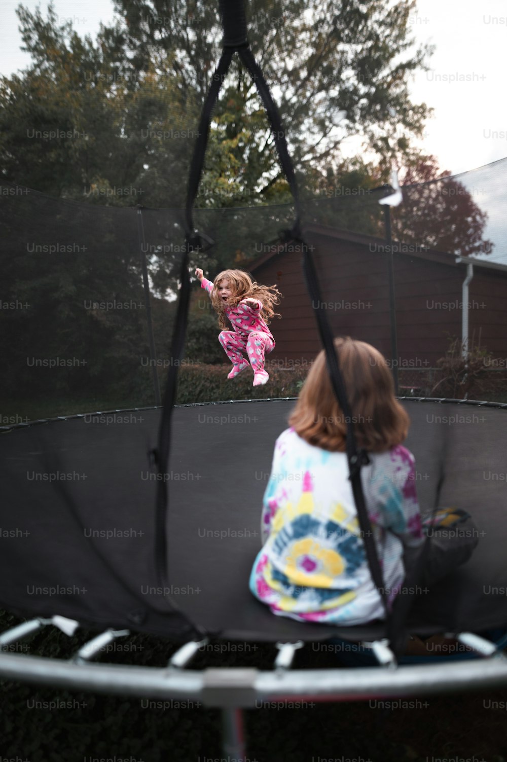 a little girl is jumping on a trampoline