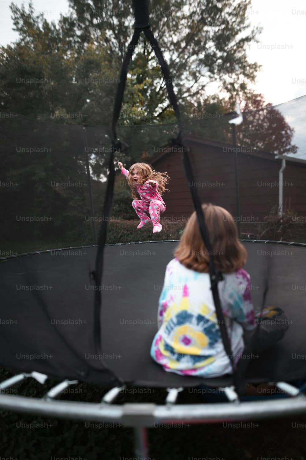 Ein kleines Mädchen springt auf einem Trampolin