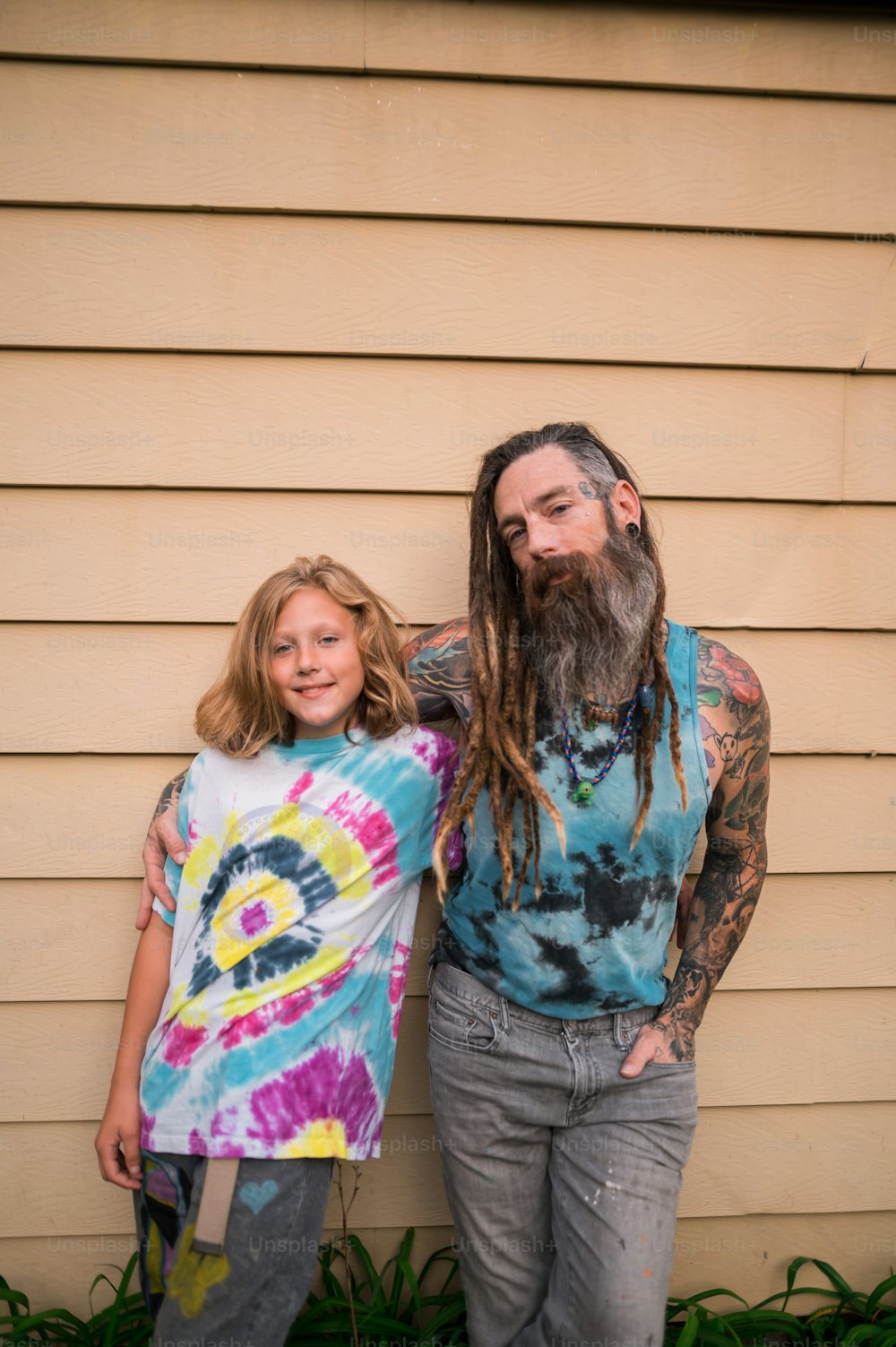 a man with a long beard standing next to a little girl