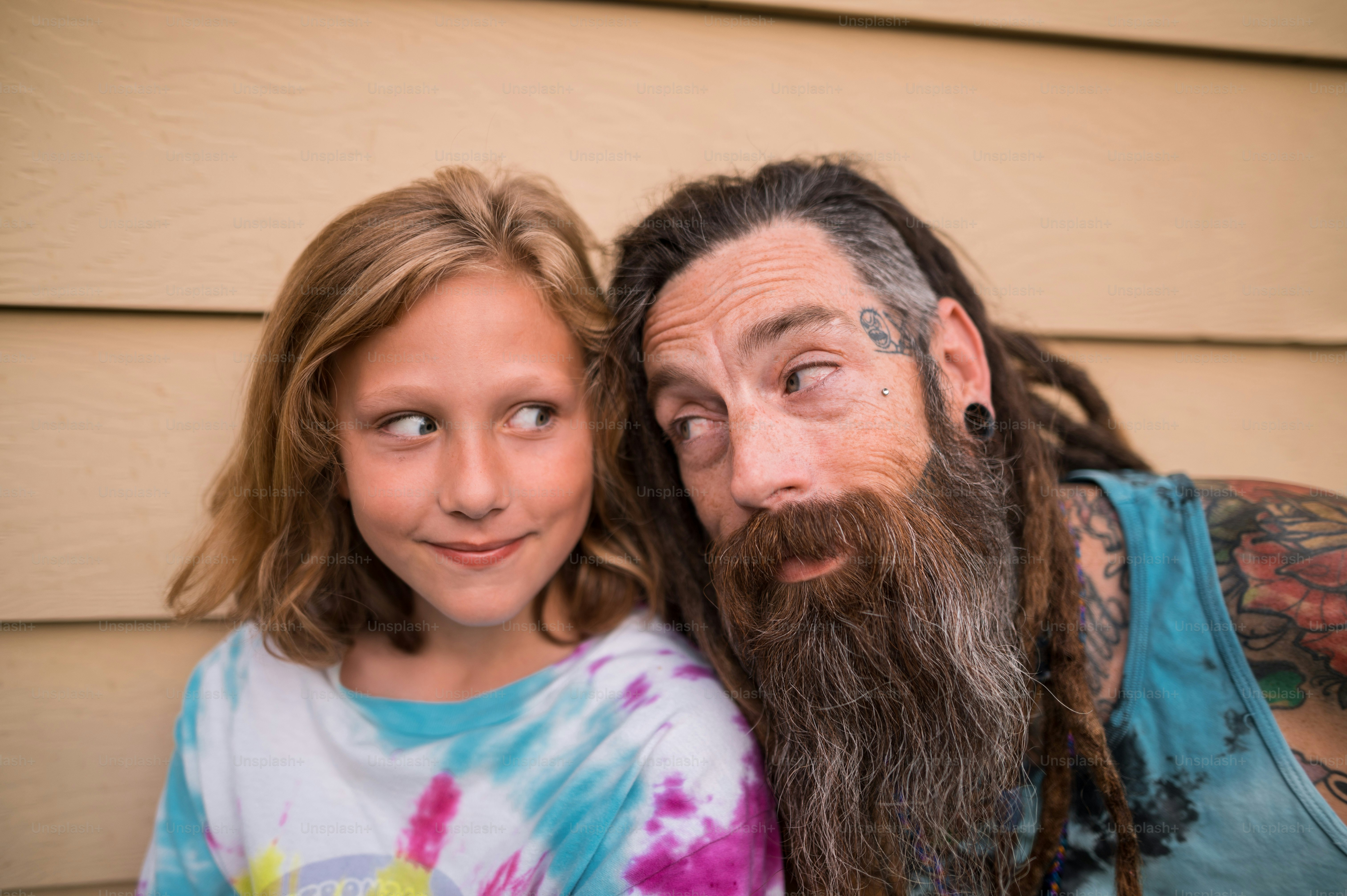 a man with a long beard standing next to a little girl