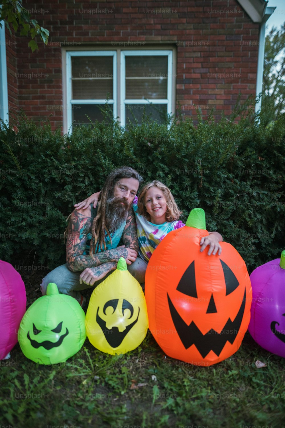 Um homem e uma menina sentados em frente aos balões de Halloween