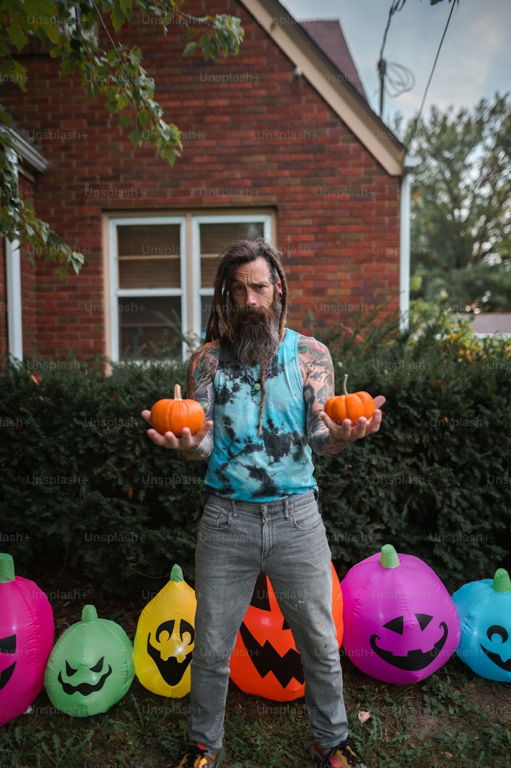a man standing in front of a bunch of fake pumpkins