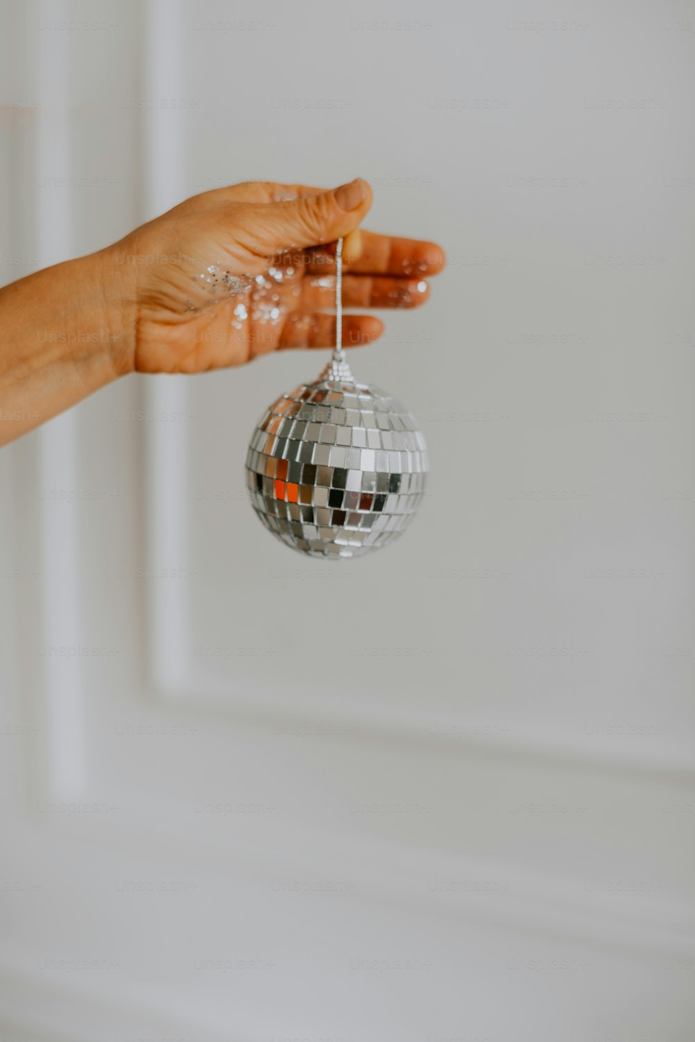 a person holding a disco ball in their hand