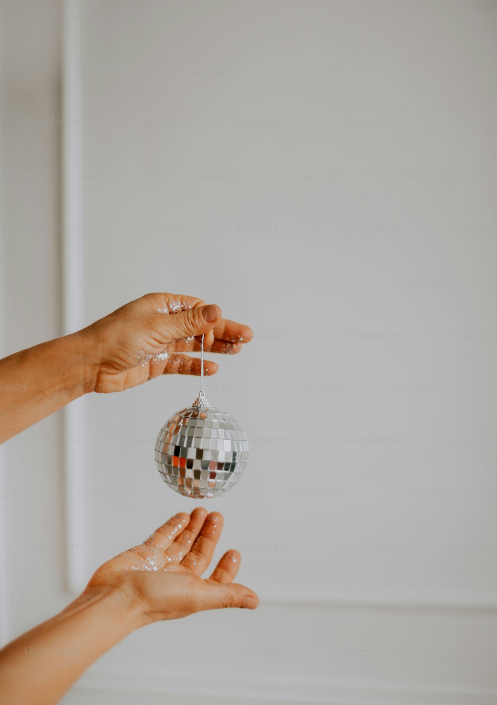 a person holding a disco ball in their hands