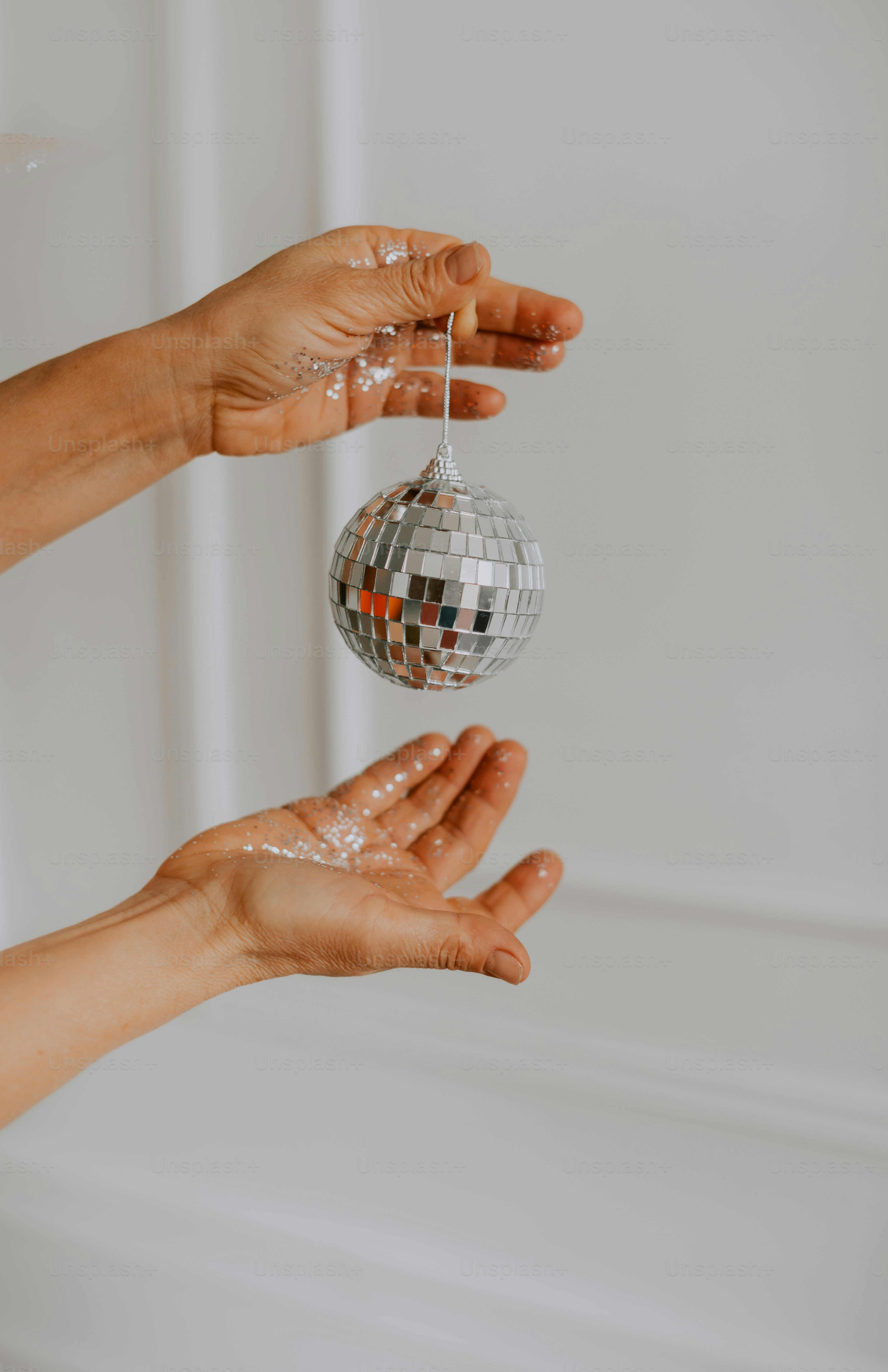 eine Person, die eine Discokugel in den Händen hält