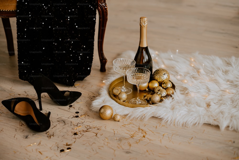 a pair of high heeled shoes next to a bottle of champagne