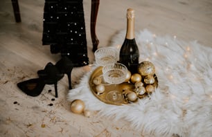 a table topped with a bottle of champagne and christmas ornaments