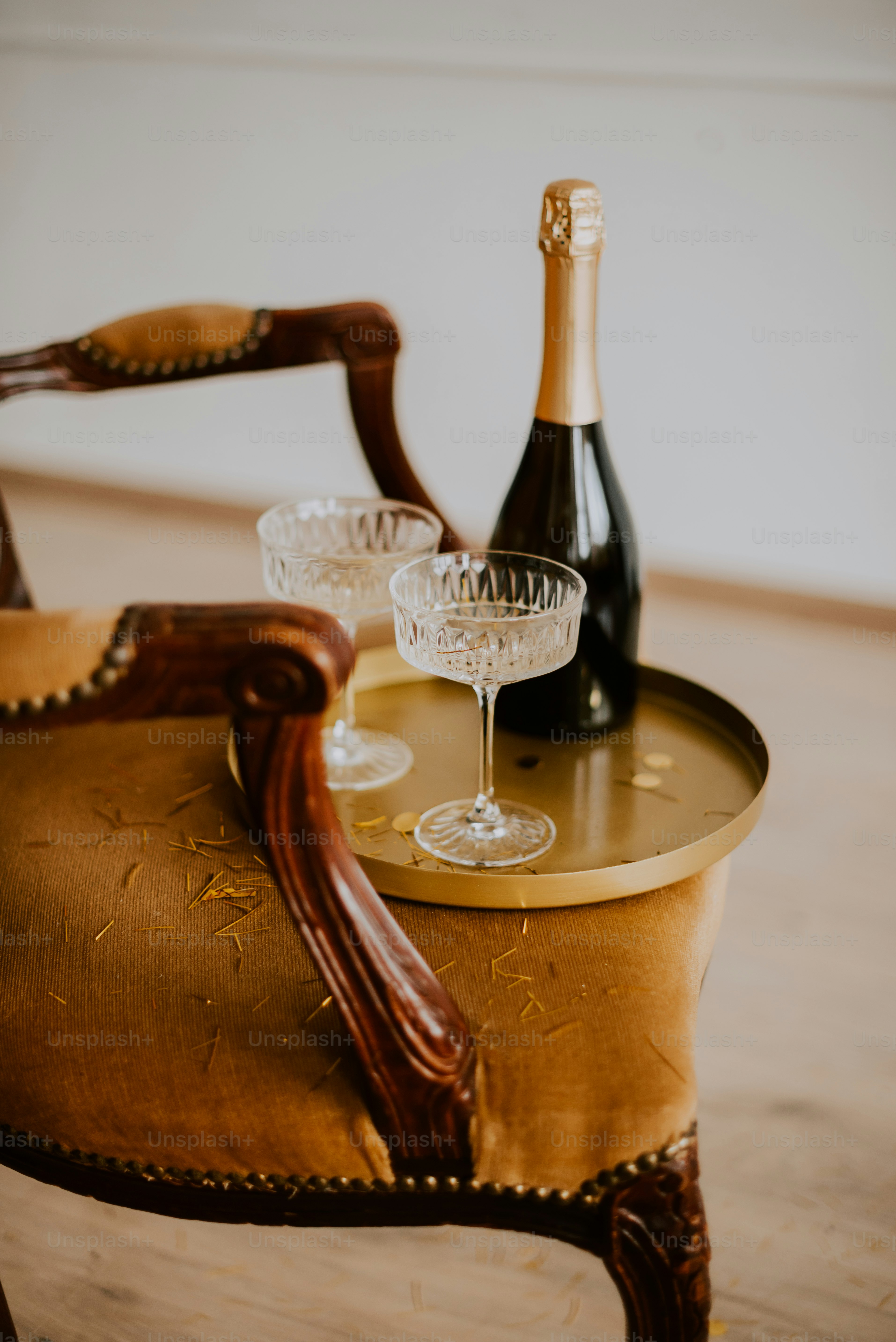 a bottle of wine and two glasses on a chair