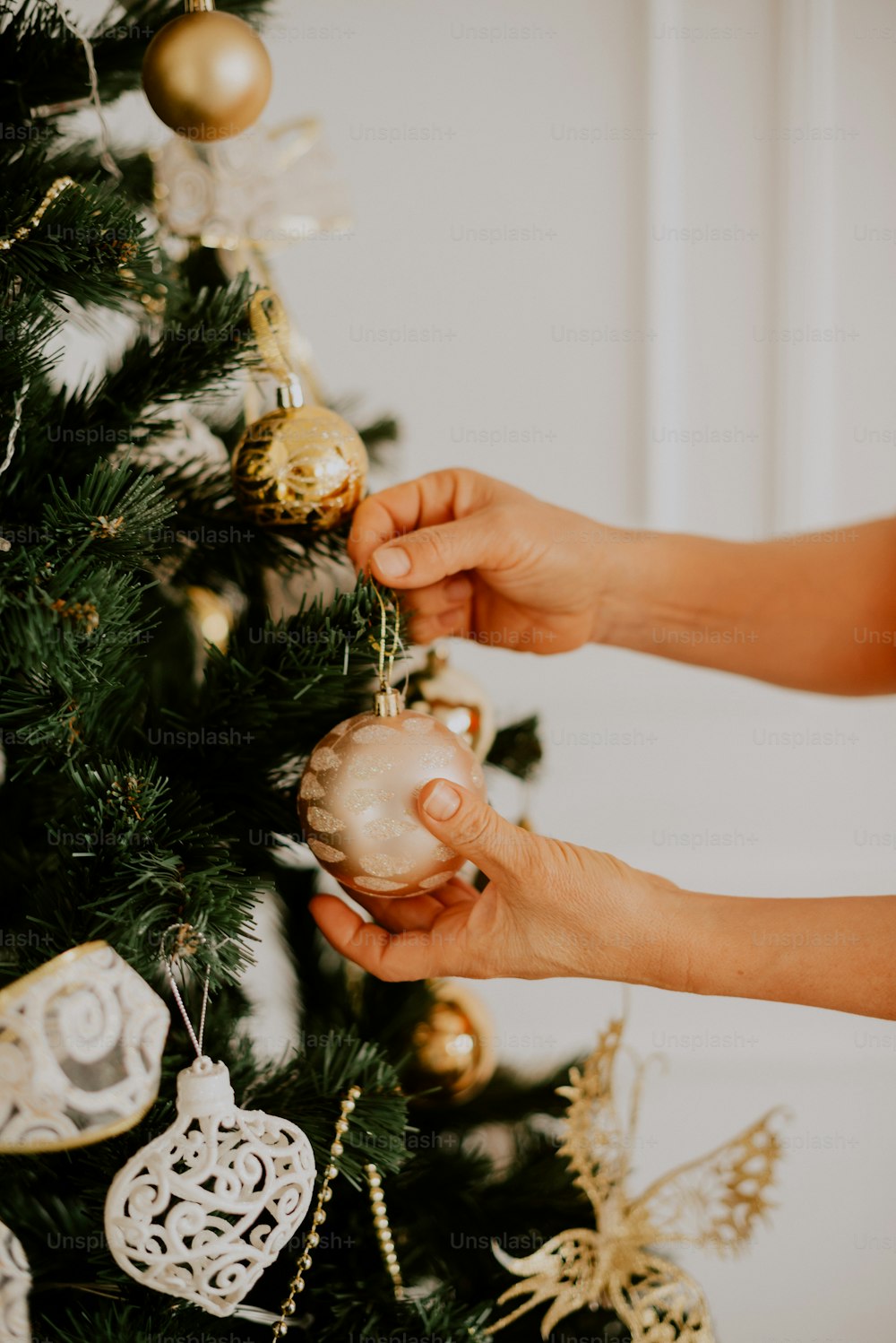 Una persona decorando un árbol de Navidad con adornos