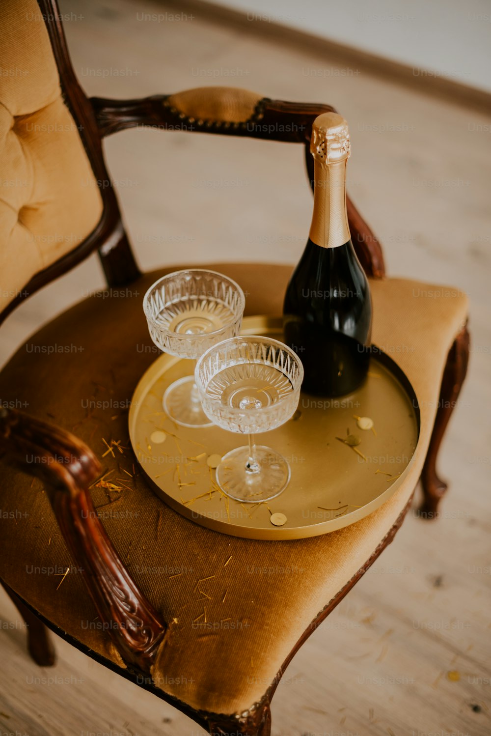 a bottle of wine sitting on top of a wooden chair