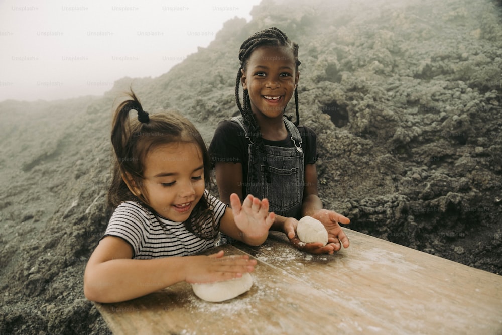 Deux jeunes filles assises à une table avec de la pâte