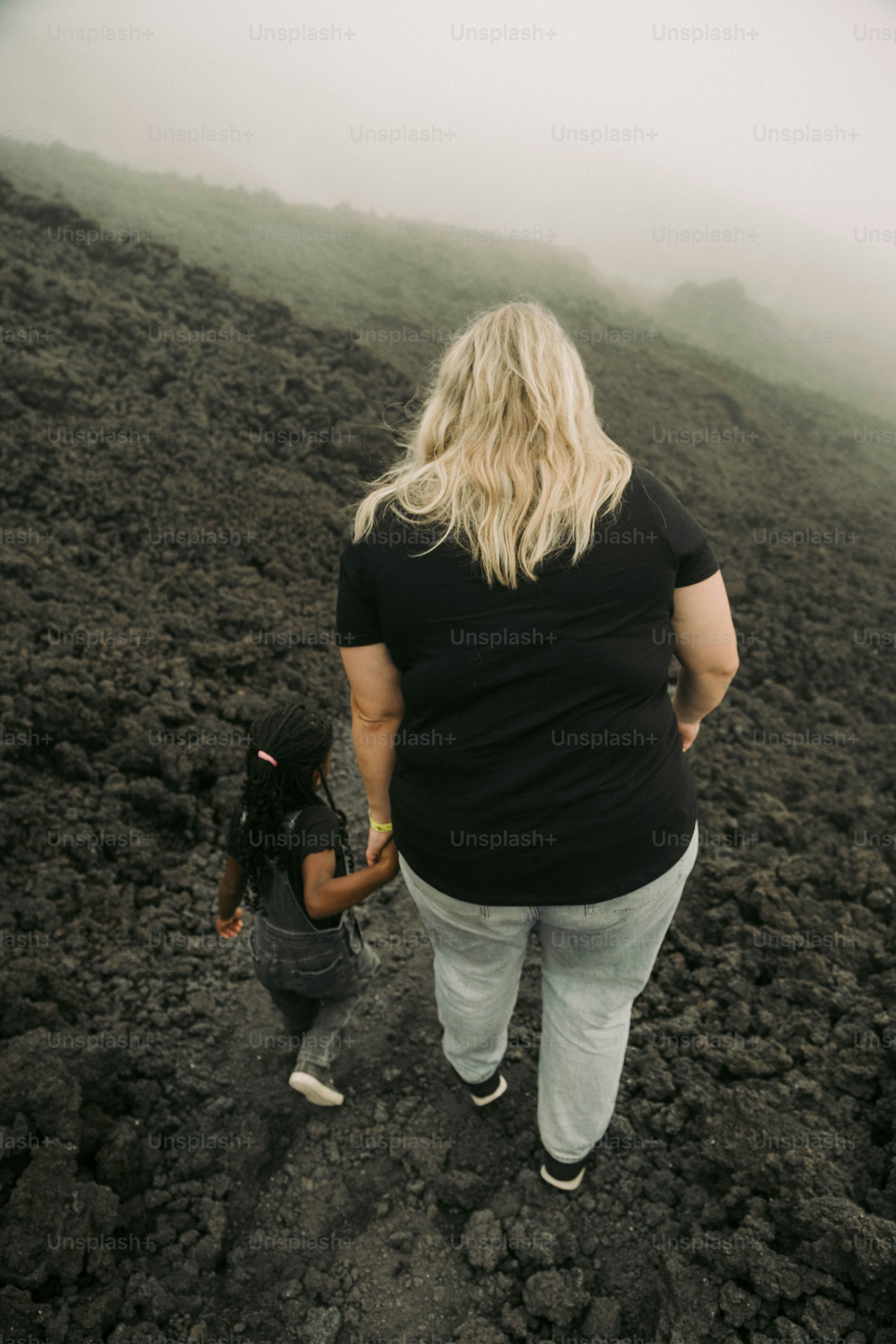 a woman and a child are standing in a field