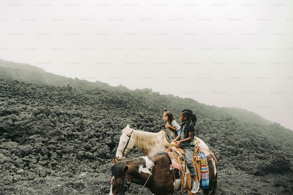 um casal de pessoas montado no lombo de um cavalo marrom e branco