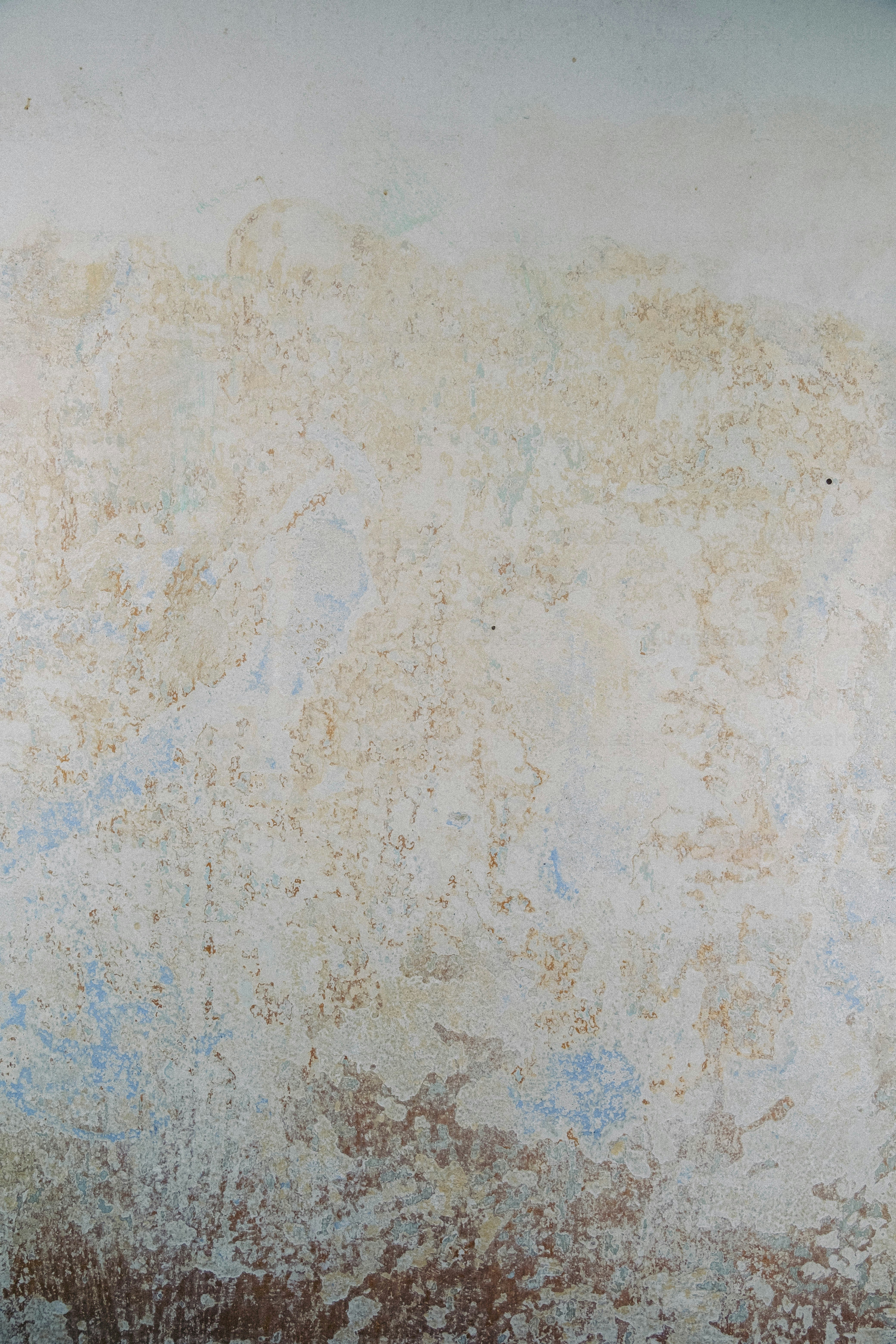 a white wall with blue and brown paint on it