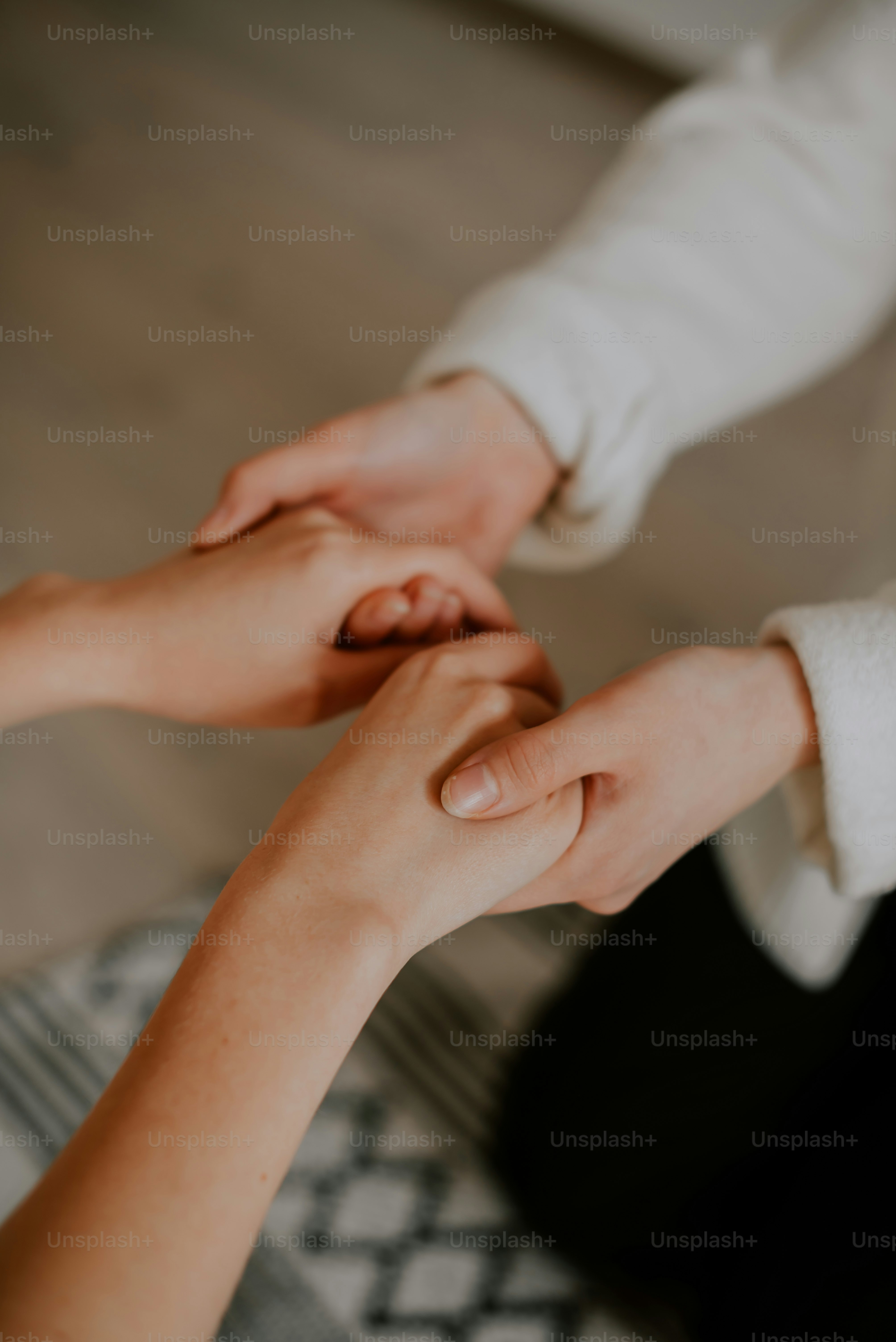 a close up of two people holding hands