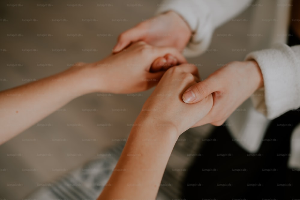 a close up of two people holding hands