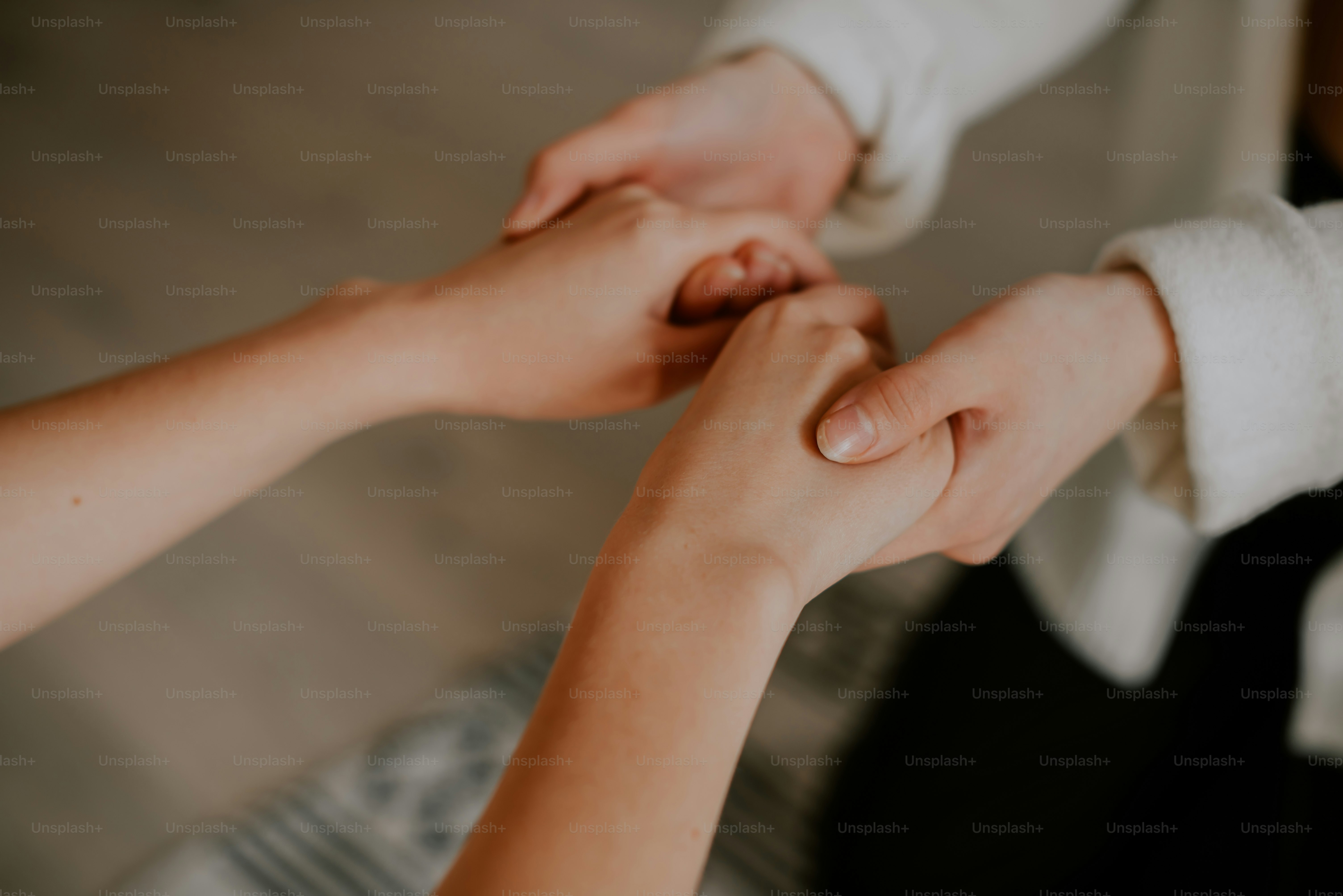 a close up of two people holding hands