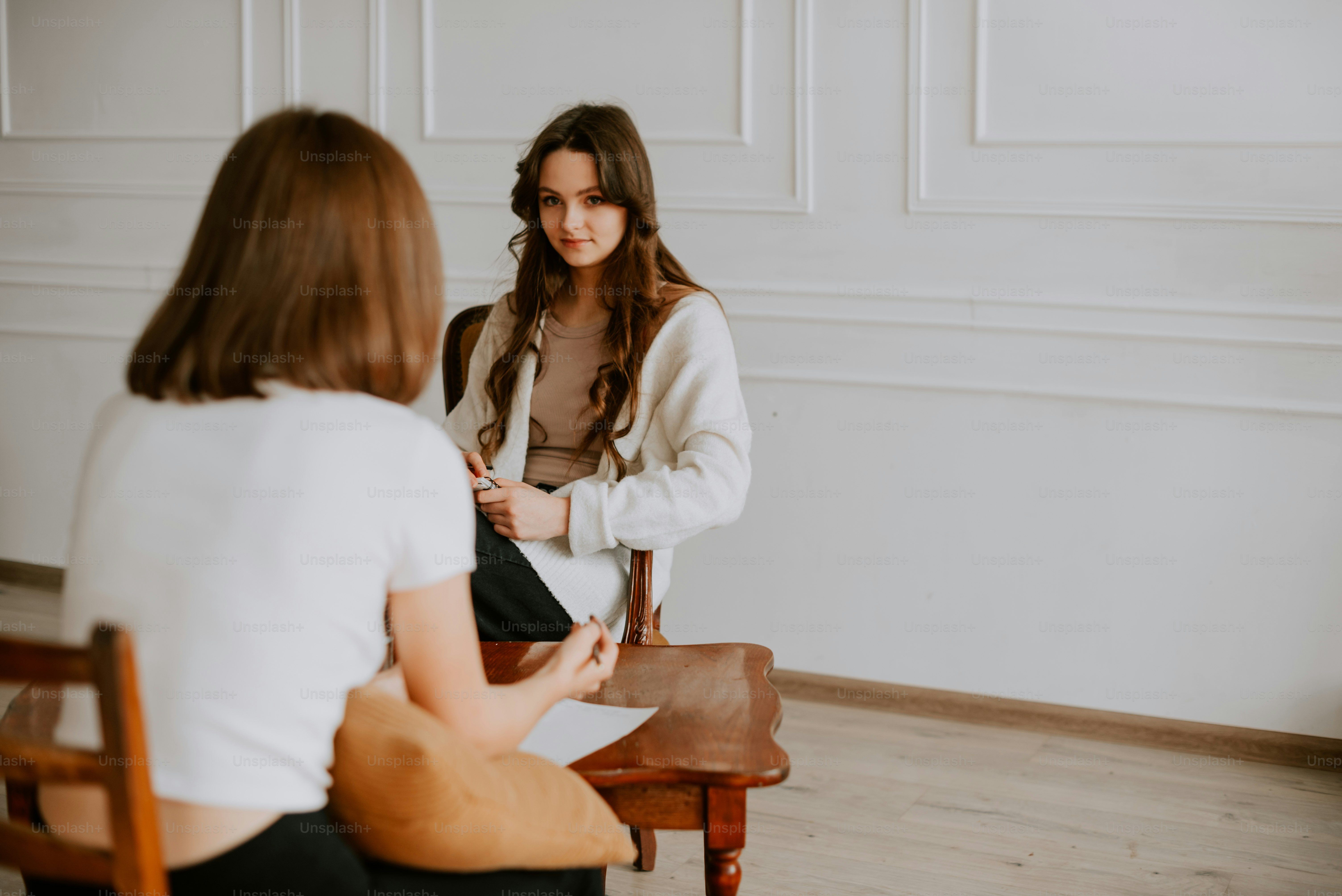 Une femme assise sur une chaise devant un miroir