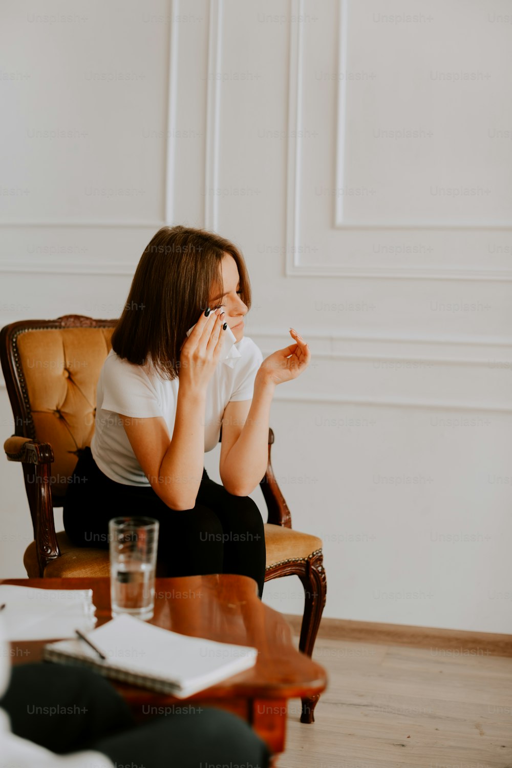 uma mulher sentada em uma cadeira segurando um cigarro