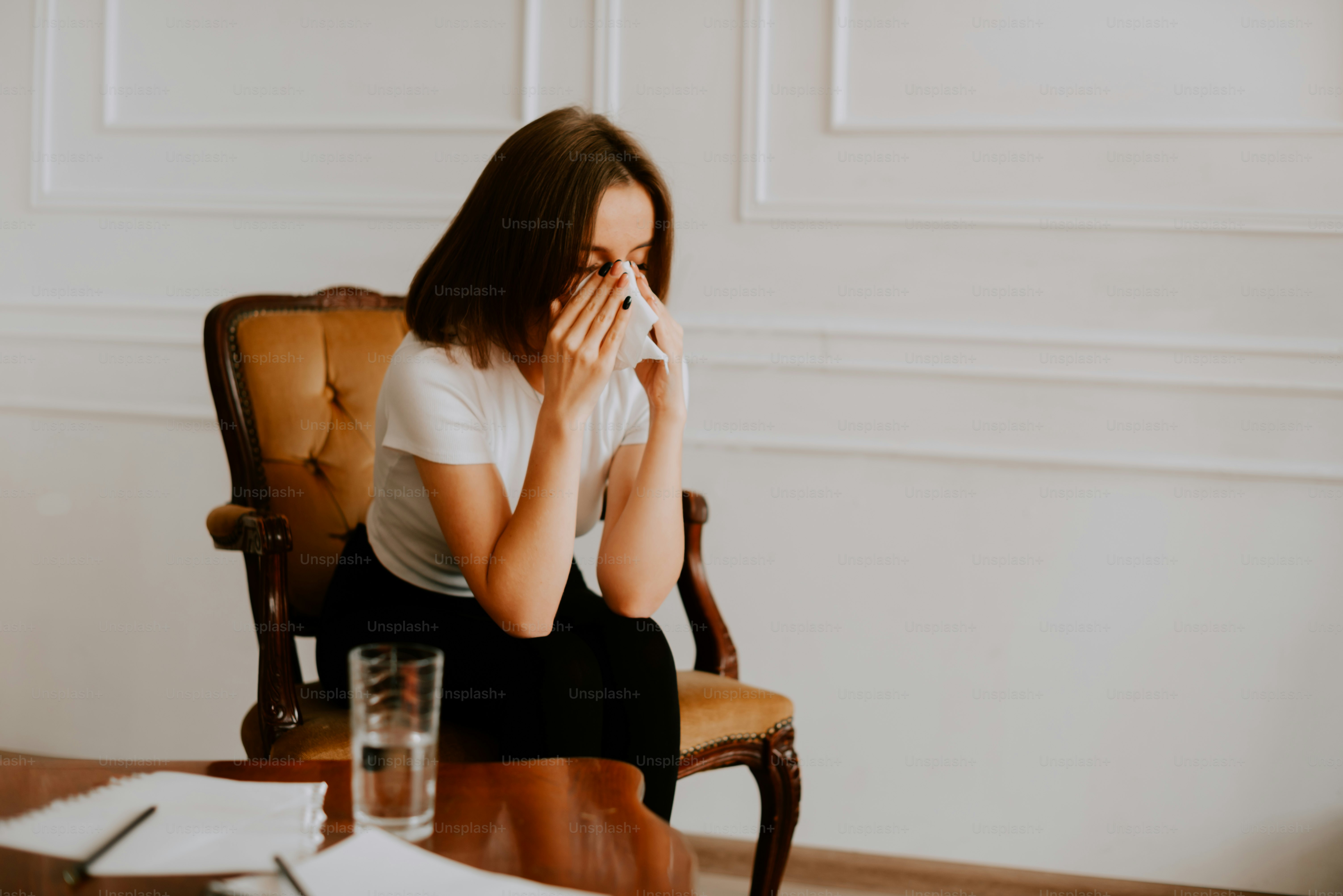 a woman sitting in a chair with her hand on her face