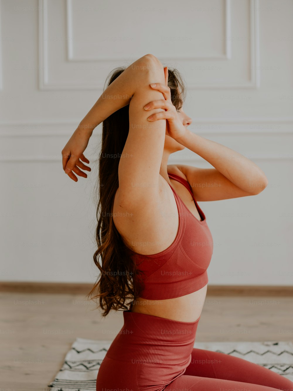a woman in a red sports bra top doing yoga