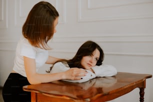 Una mujer sentada en una mesa con una niña