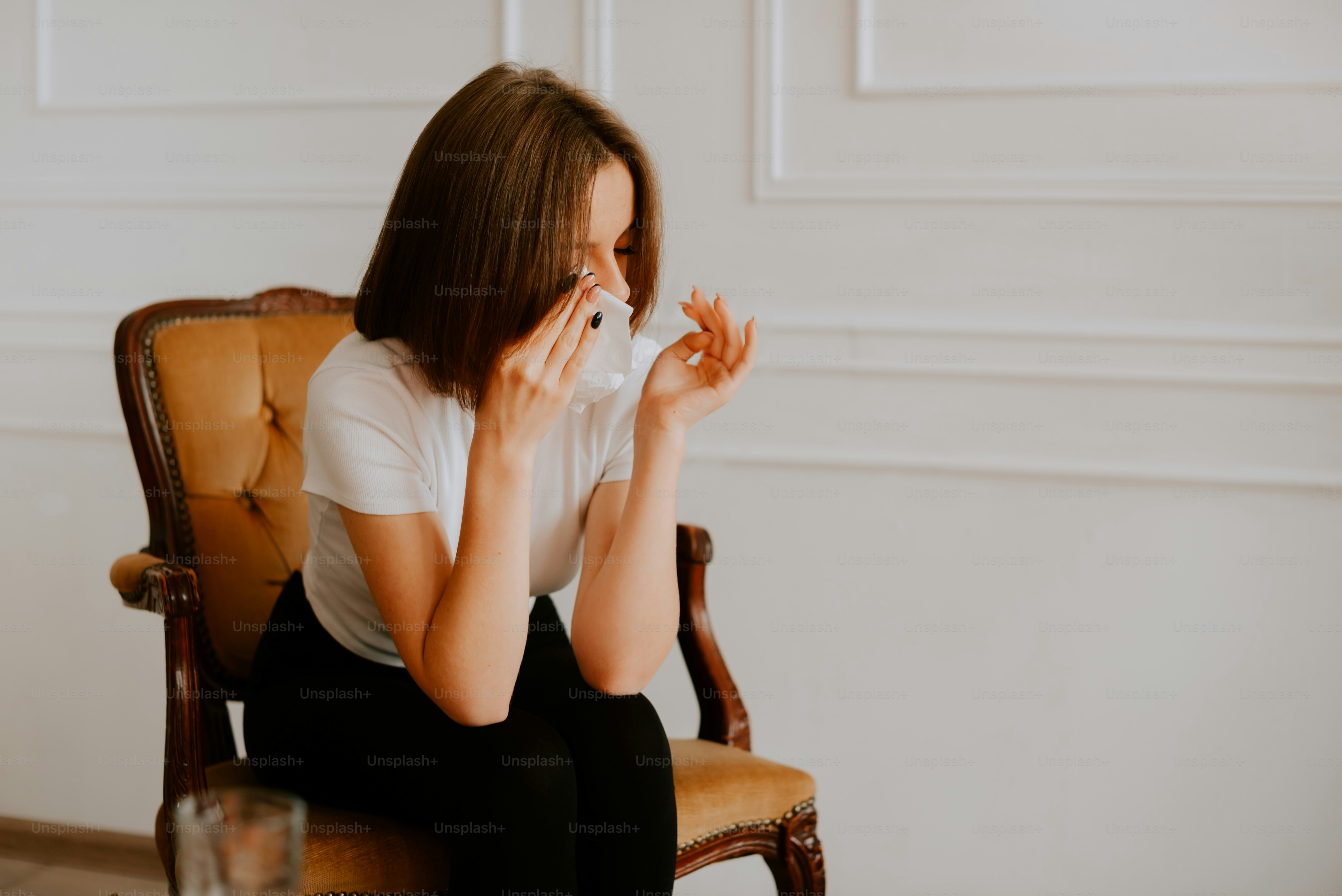 a woman sitting in a chair with a tissue in her hand