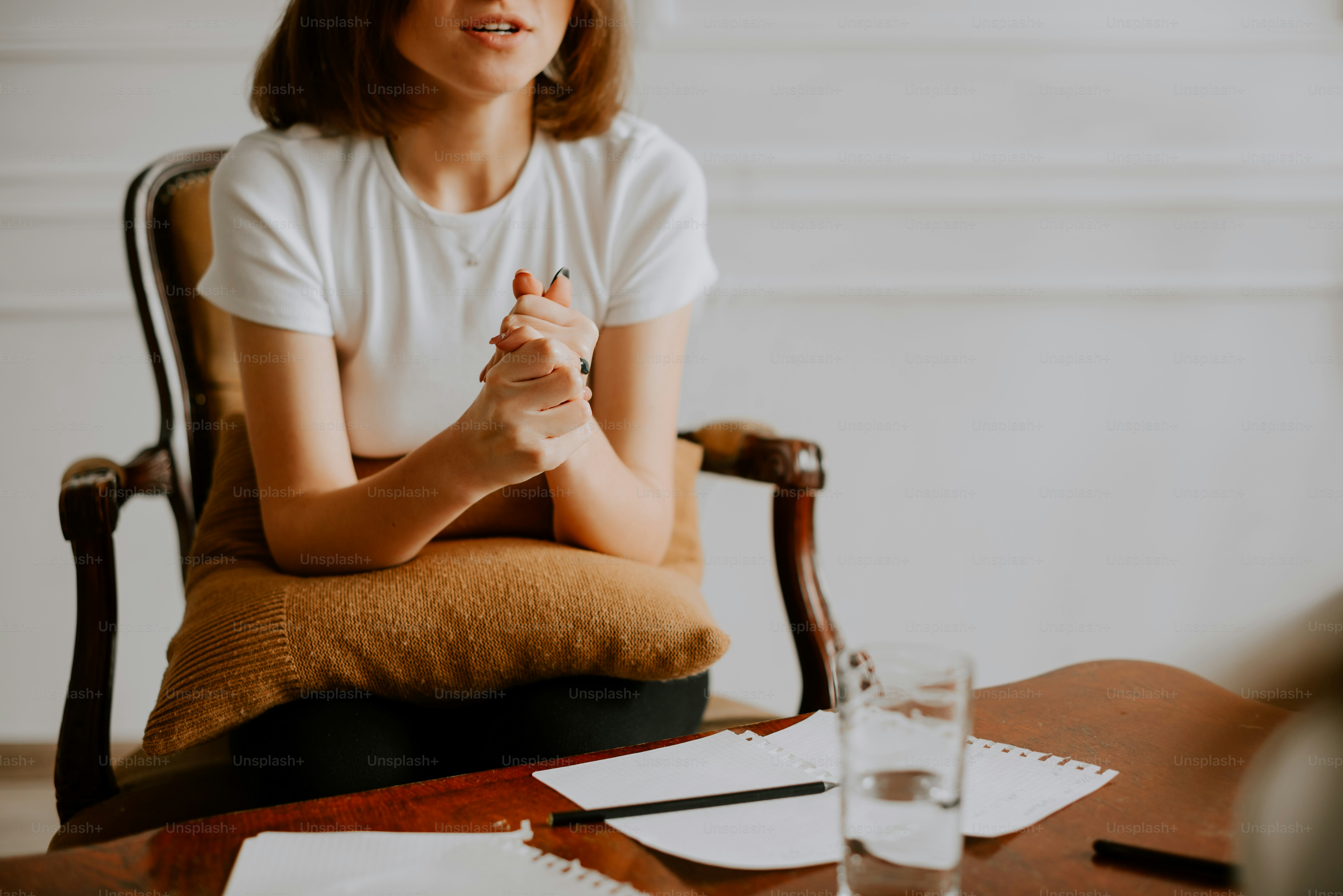 a woman sitting in a chair with a glass of water