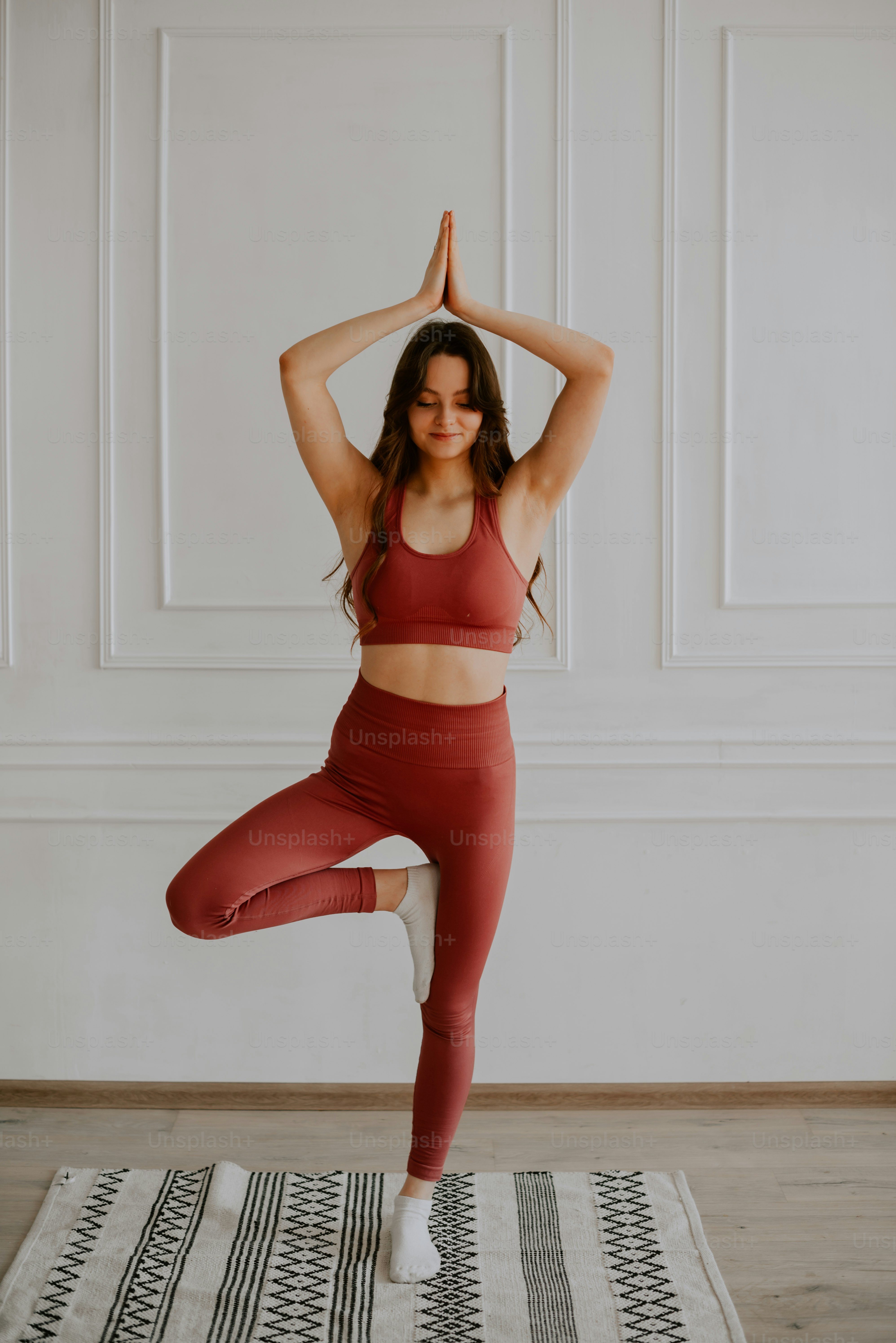 Une femme faisant une pose de yoga sur un tapis