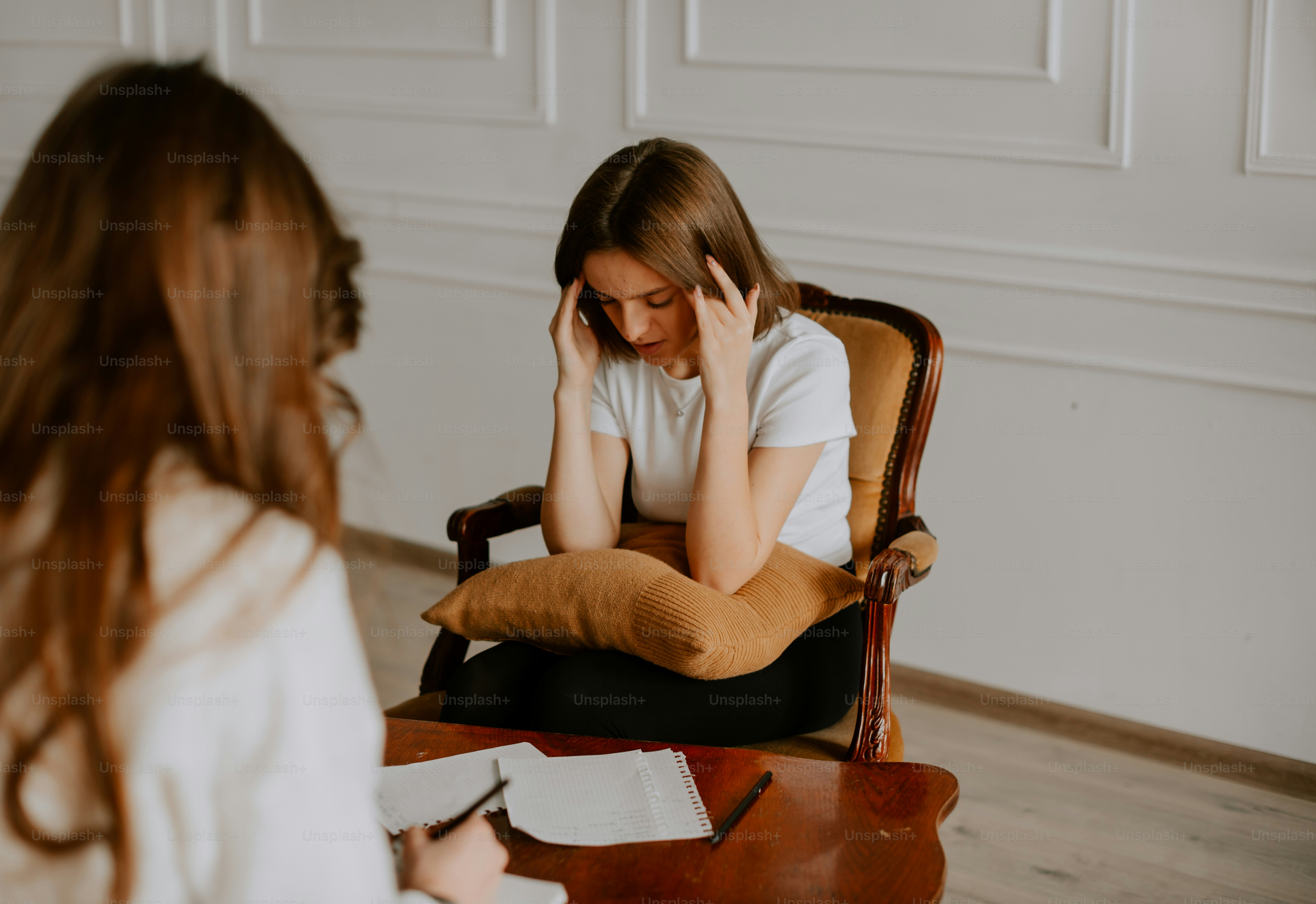 a woman sitting in a chair talking on a cell phone