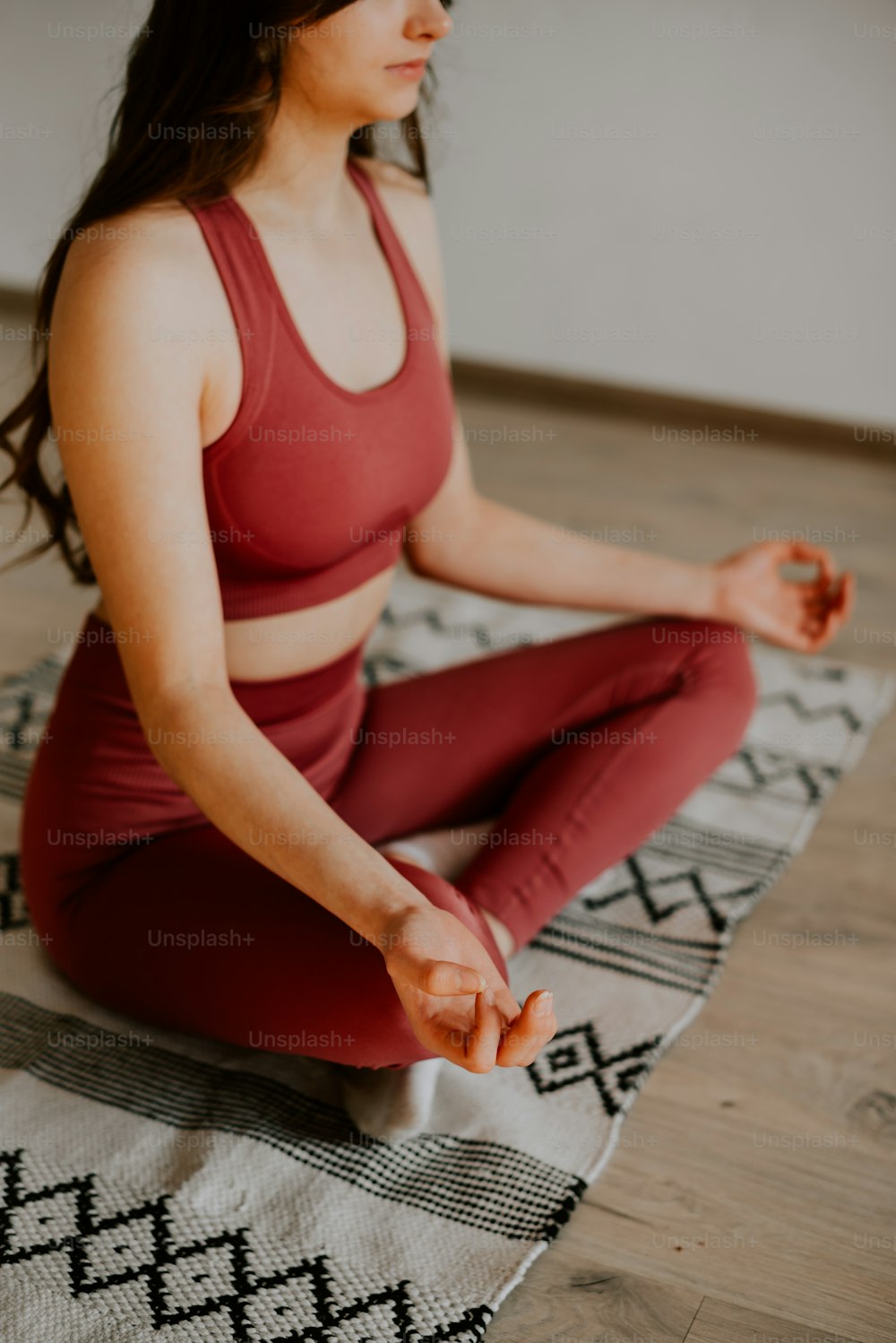 a woman sitting in a yoga position on a rug
