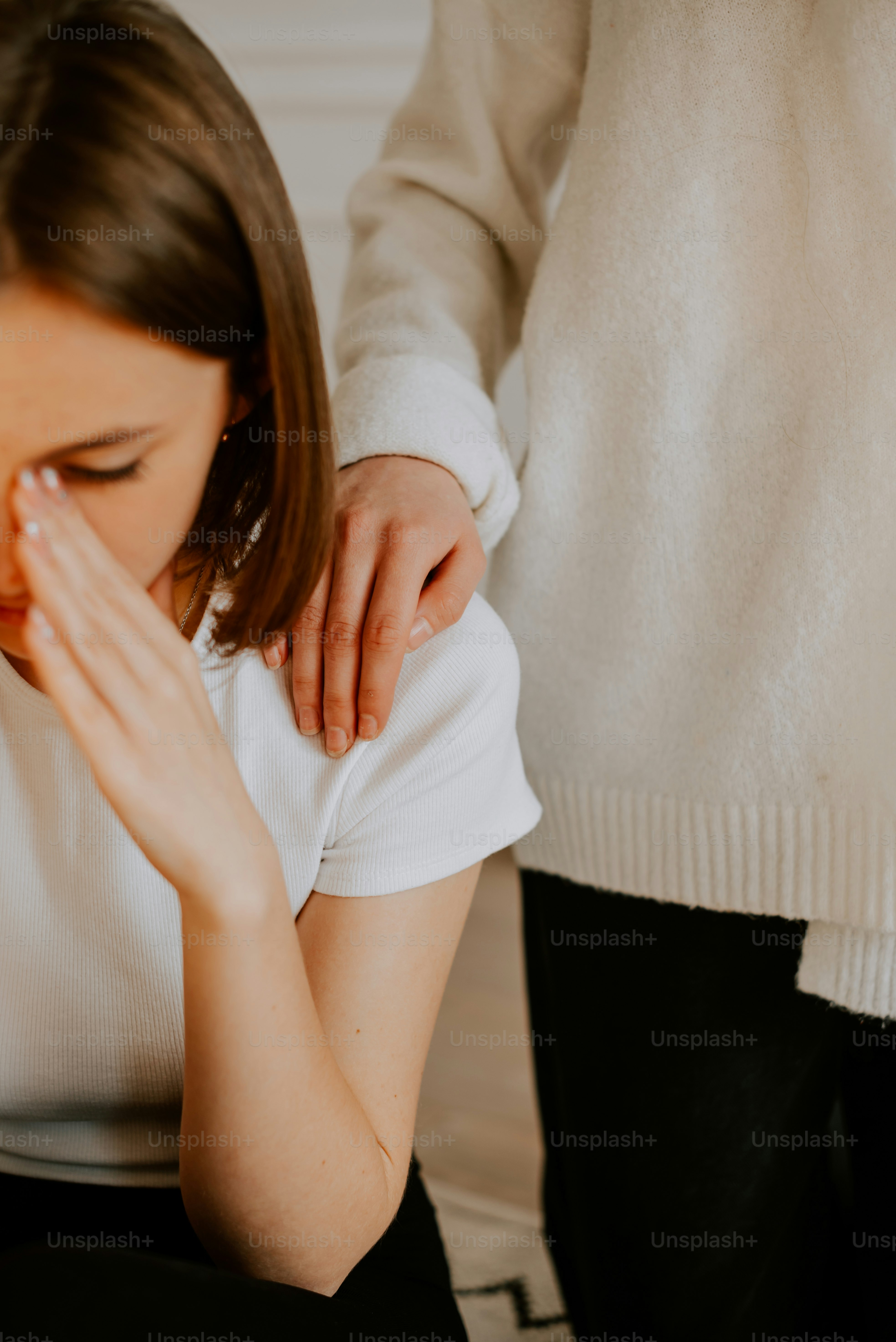 una donna che si copre il viso con le mani