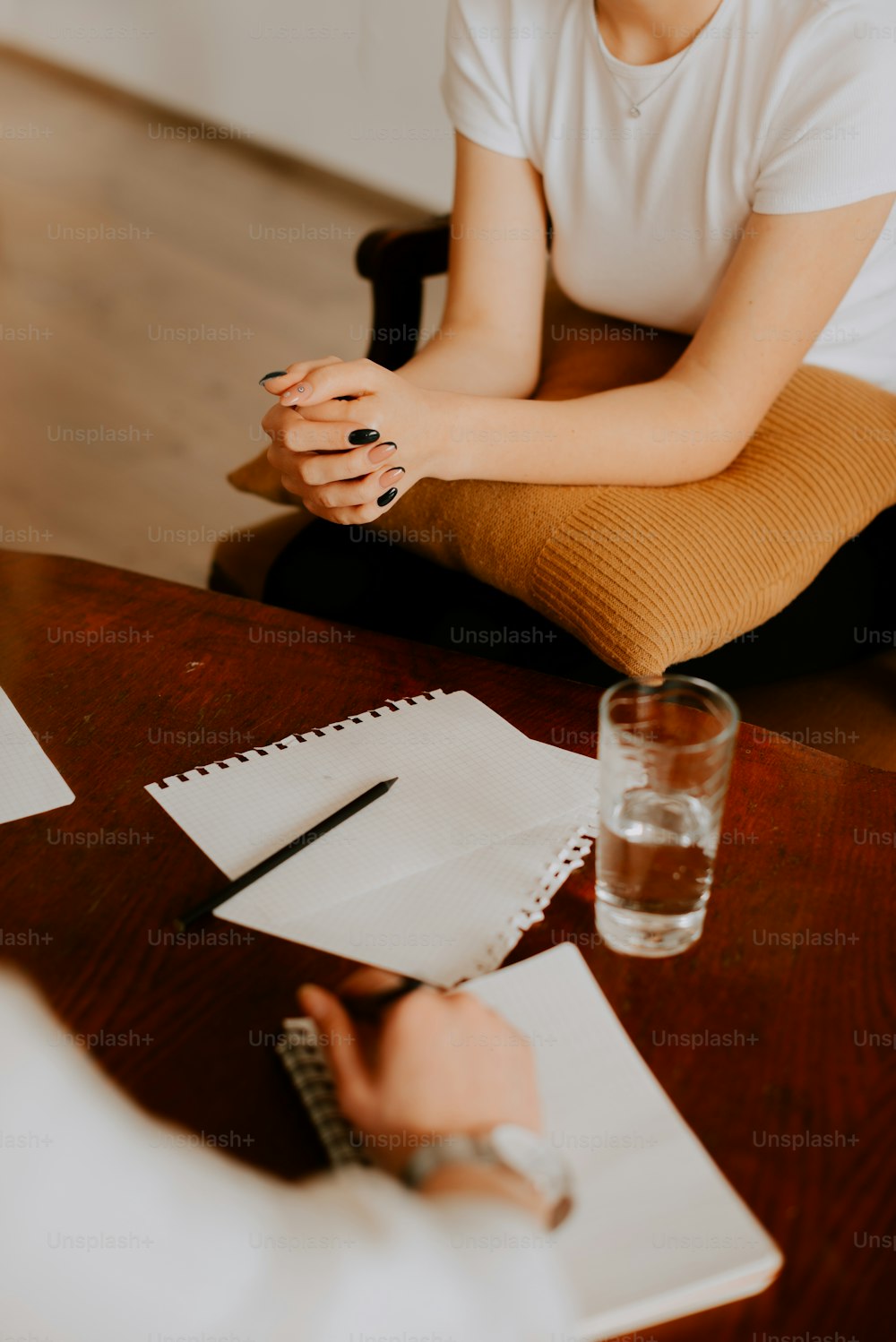 a woman sitting at a table with a glass of water