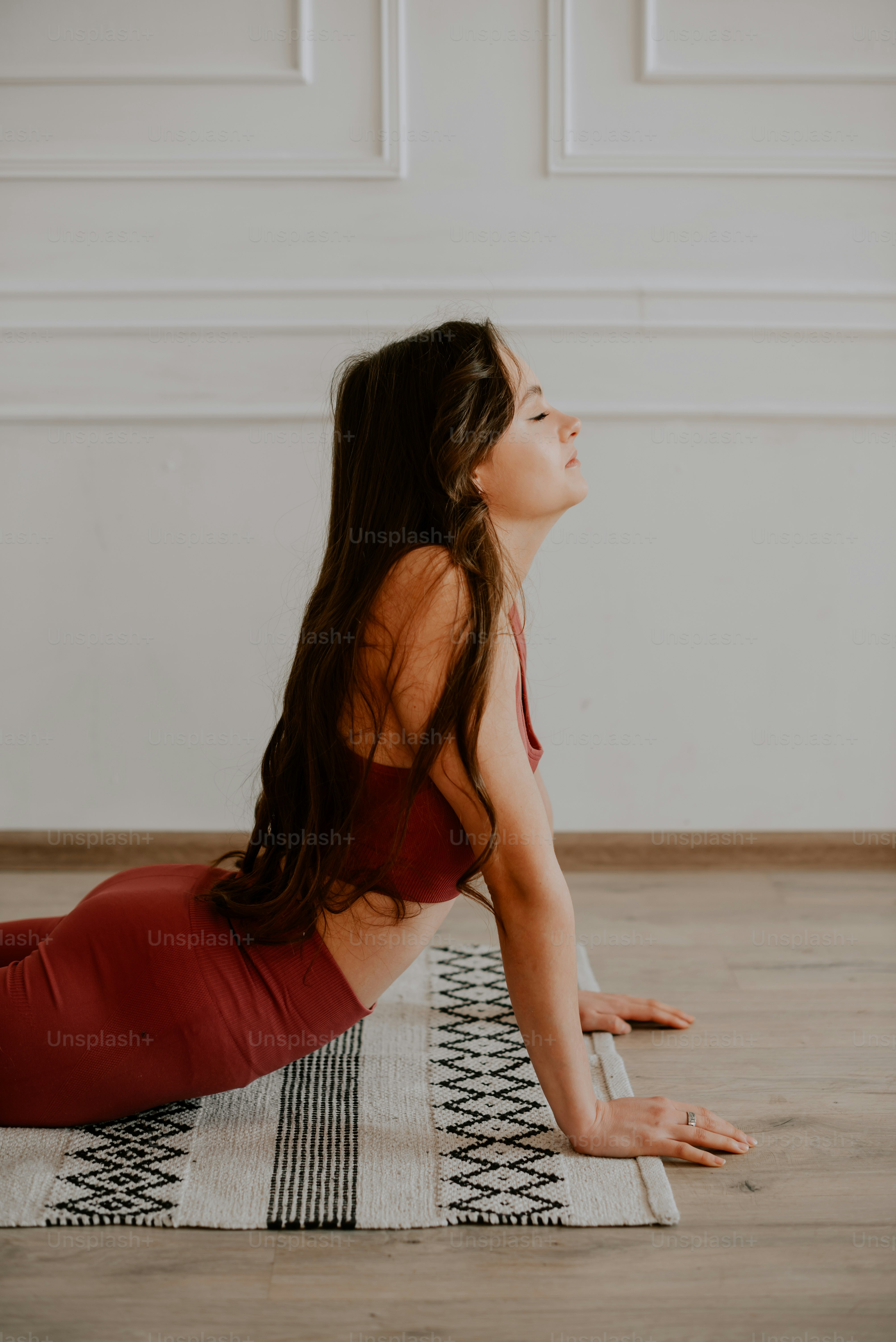 a woman in a red top is doing yoga