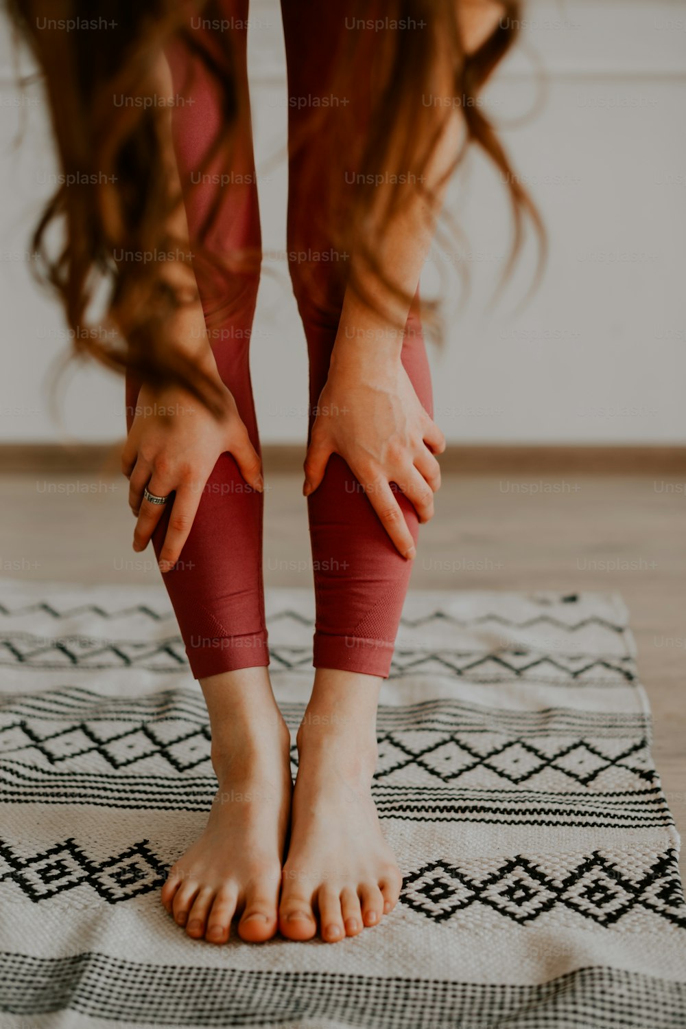 Una mujer de pie encima de una alfombra encima de un piso de madera