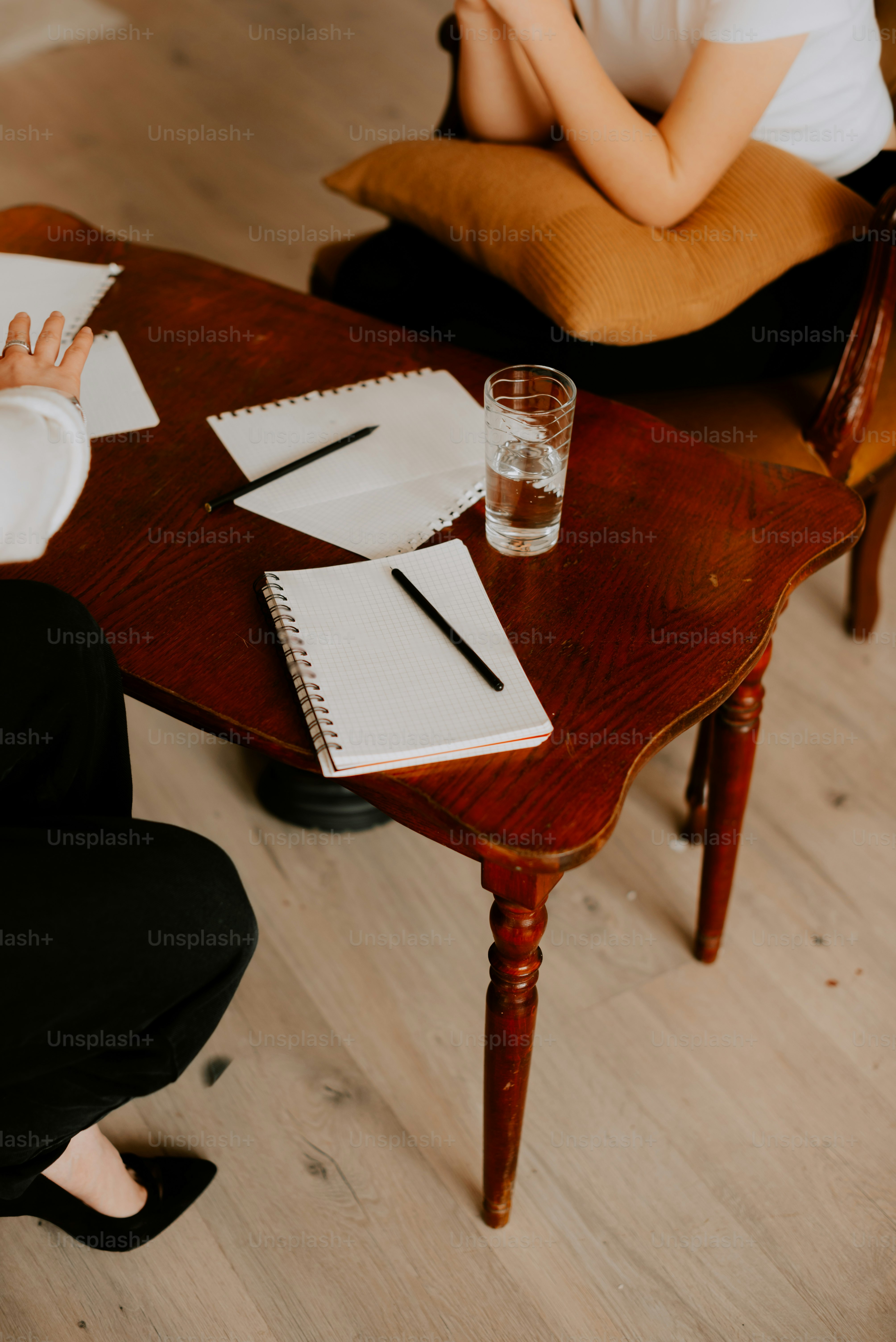 a woman sitting at a table with a glass of water