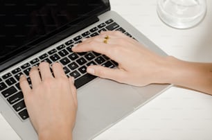 a woman is typing on a laptop computer