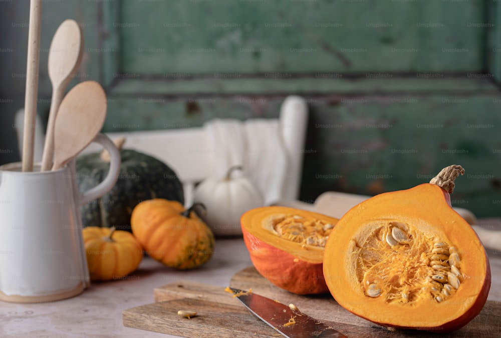 a couple of pumpkins sitting on top of a cutting board