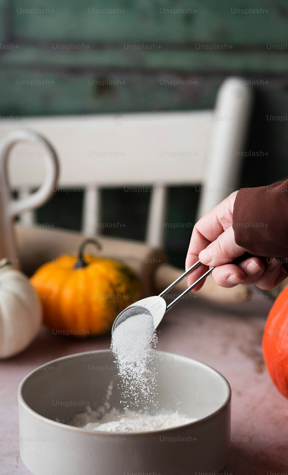 a person scooping sugar into a bowl