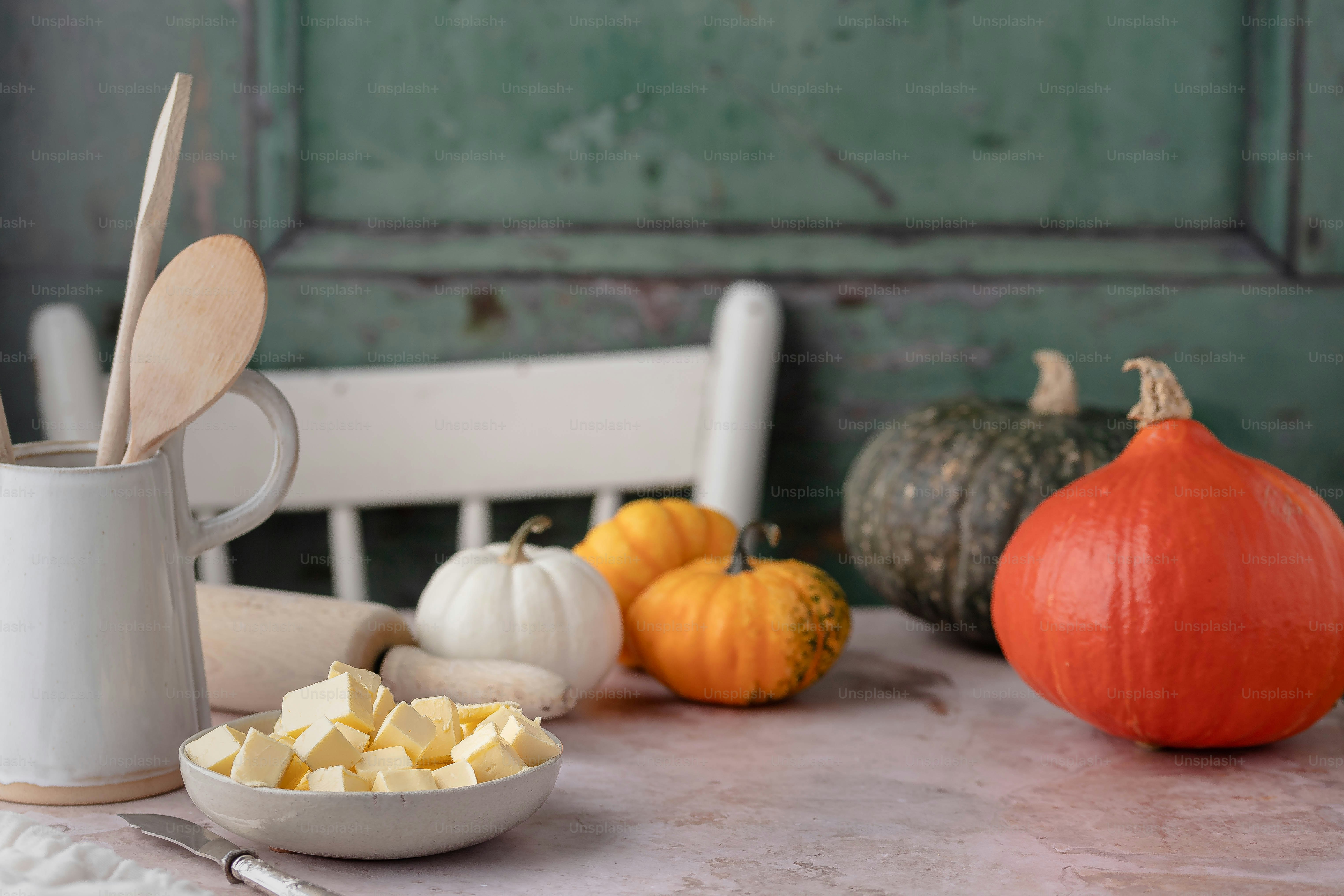 a table topped with a bowl of butter next to a cup of butter