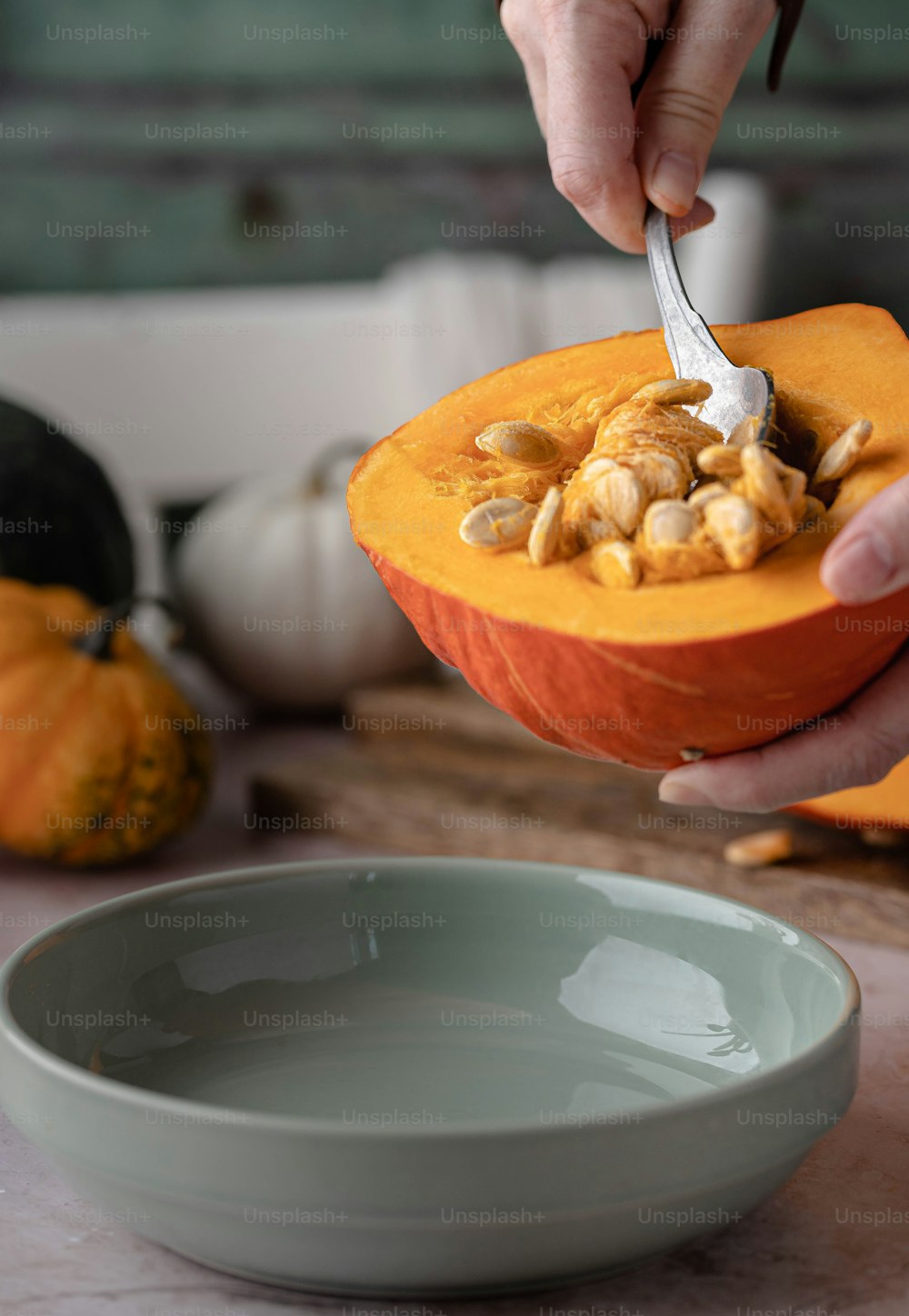 a person cutting into a pumpkin with a knife