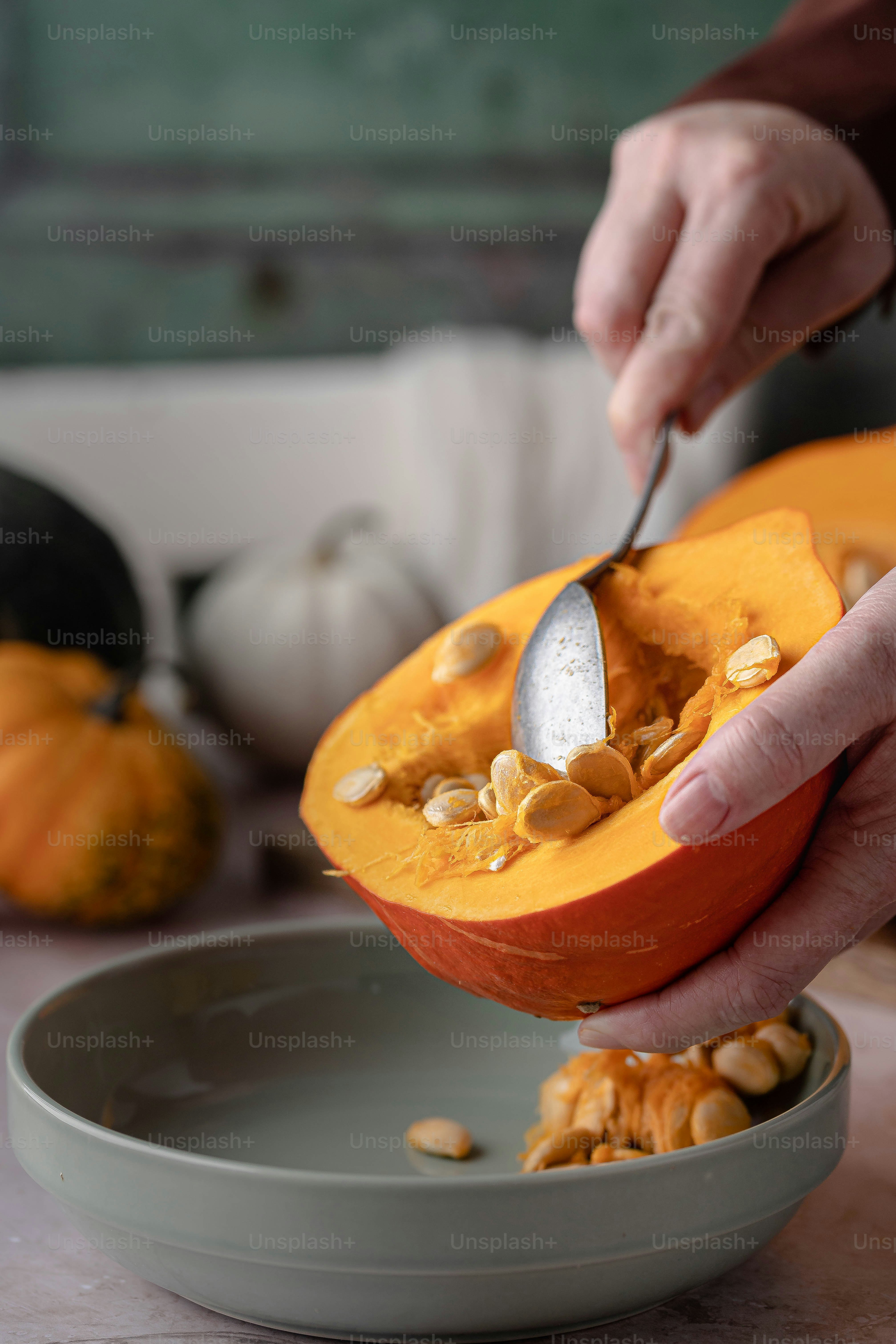 a person is scooping nuts into a pumpkin
