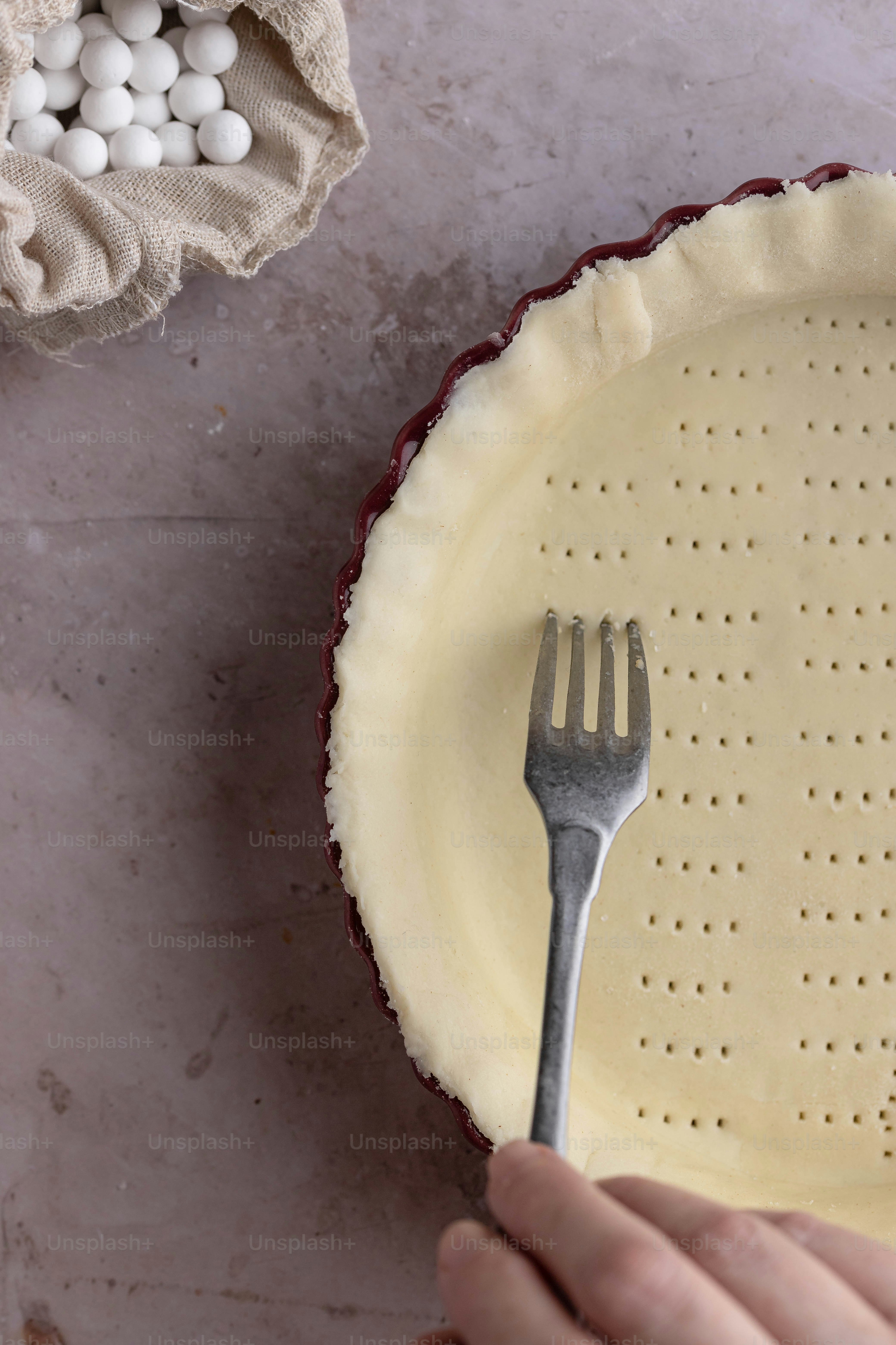 eine Person, die eine Gabel über einen Tortenboden hält