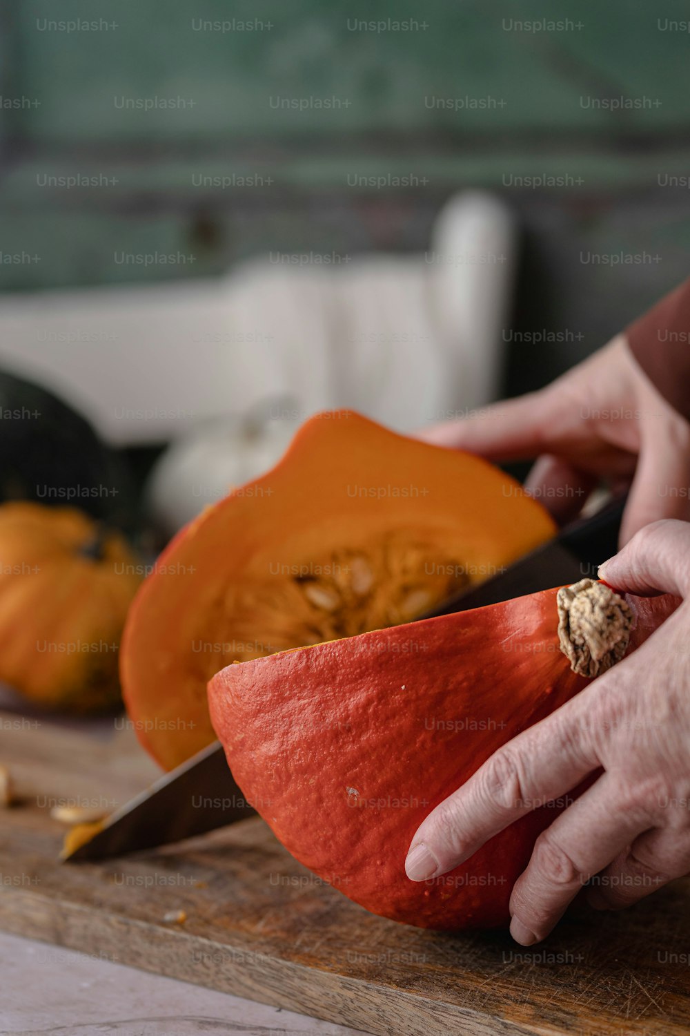 a person cutting up a pumpkin on a cutting board
