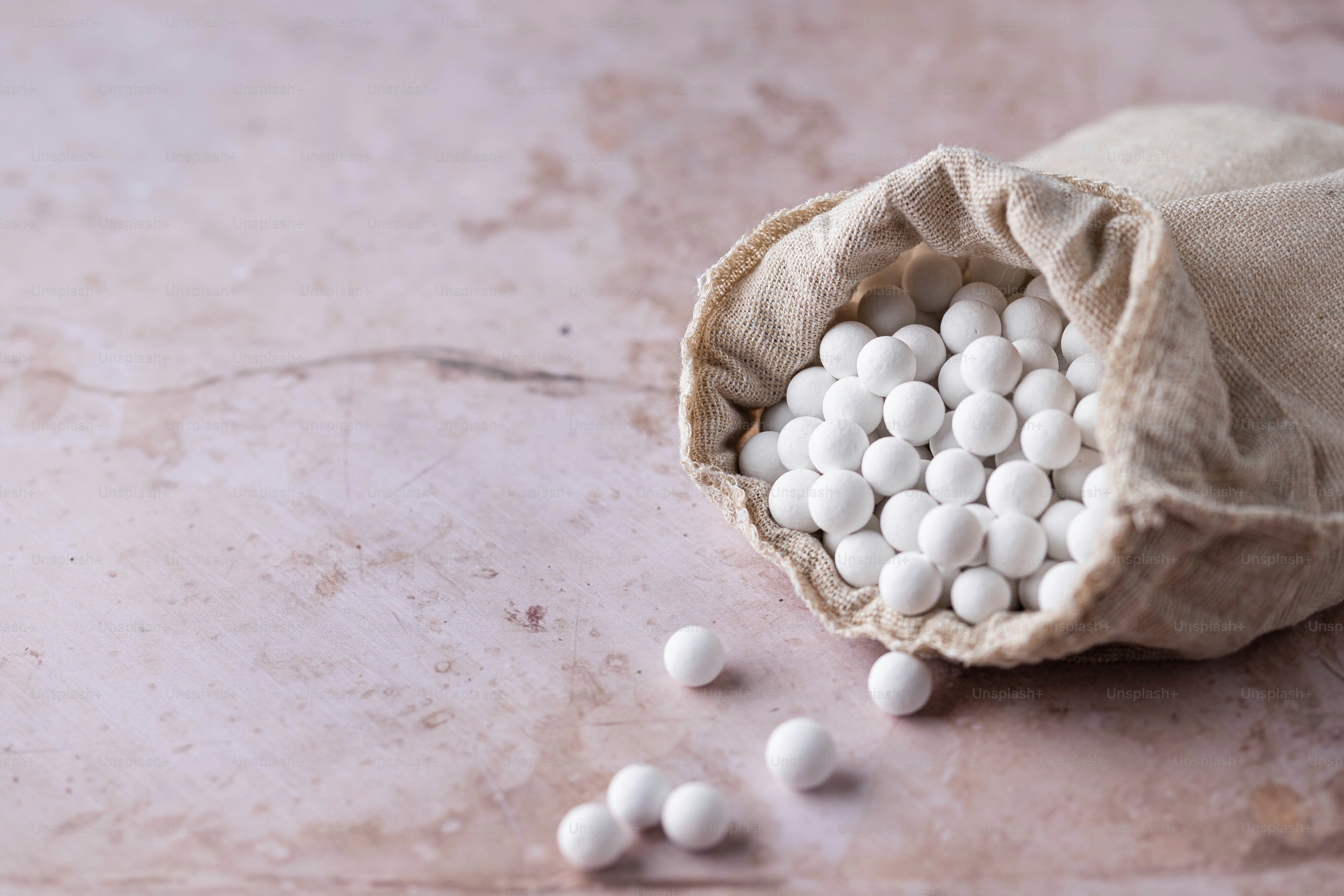 a bag filled with white pills sitting on top of a table