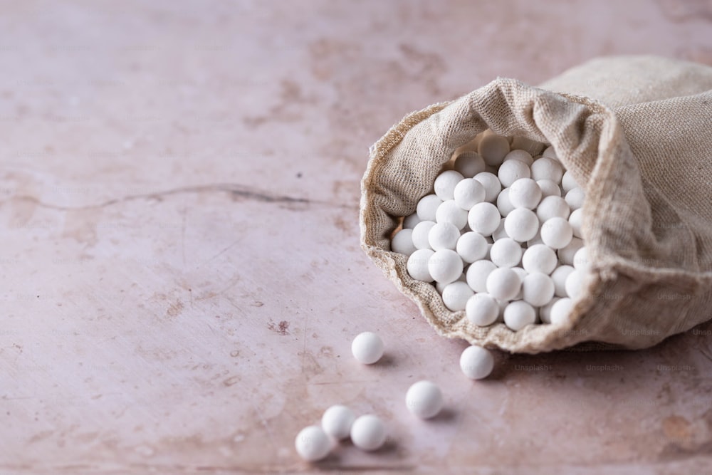 a bag filled with white pills sitting on top of a table