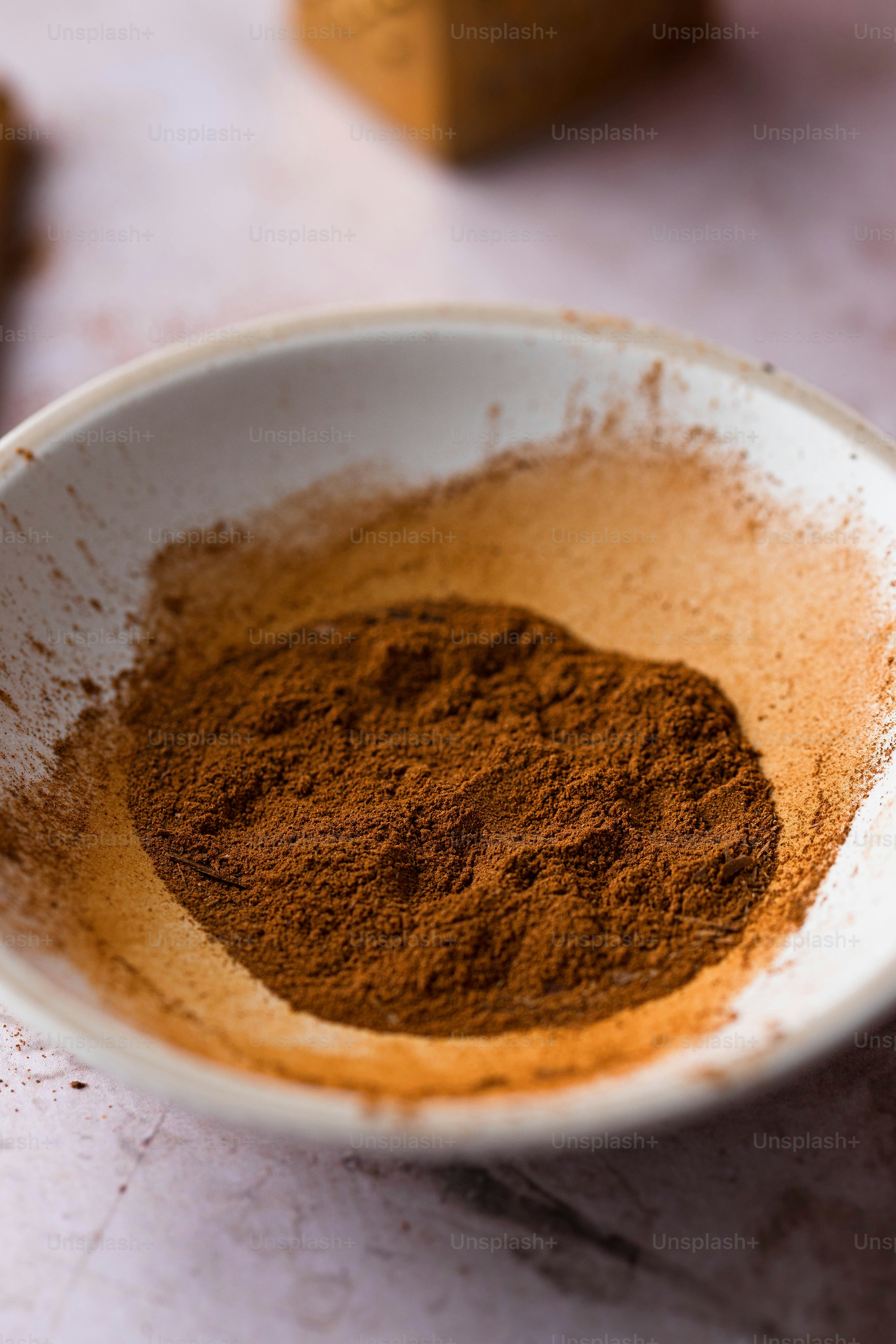a white bowl filled with brown powder on top of a table