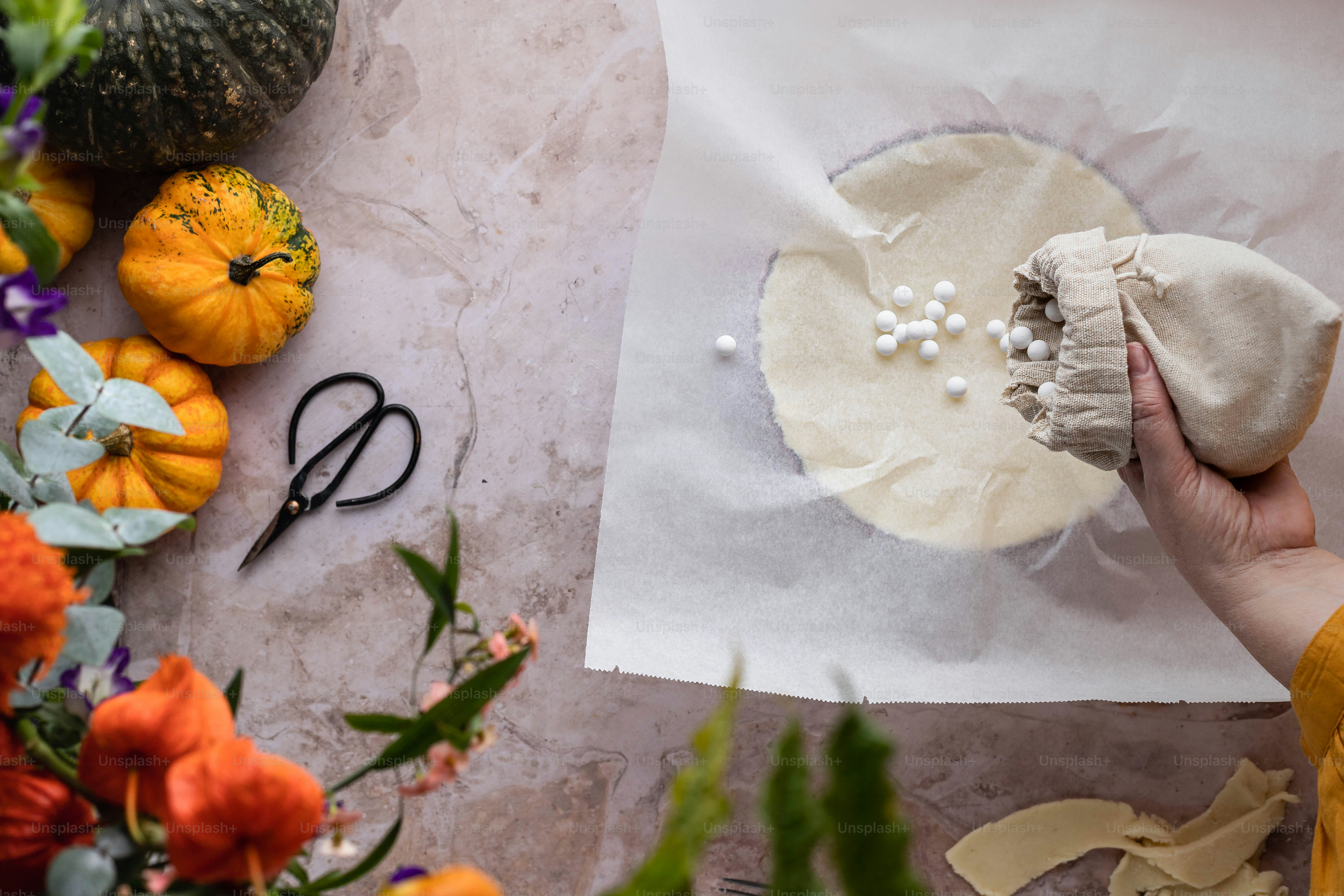 a person holding a piece of cloth next to a bunch of flowers
